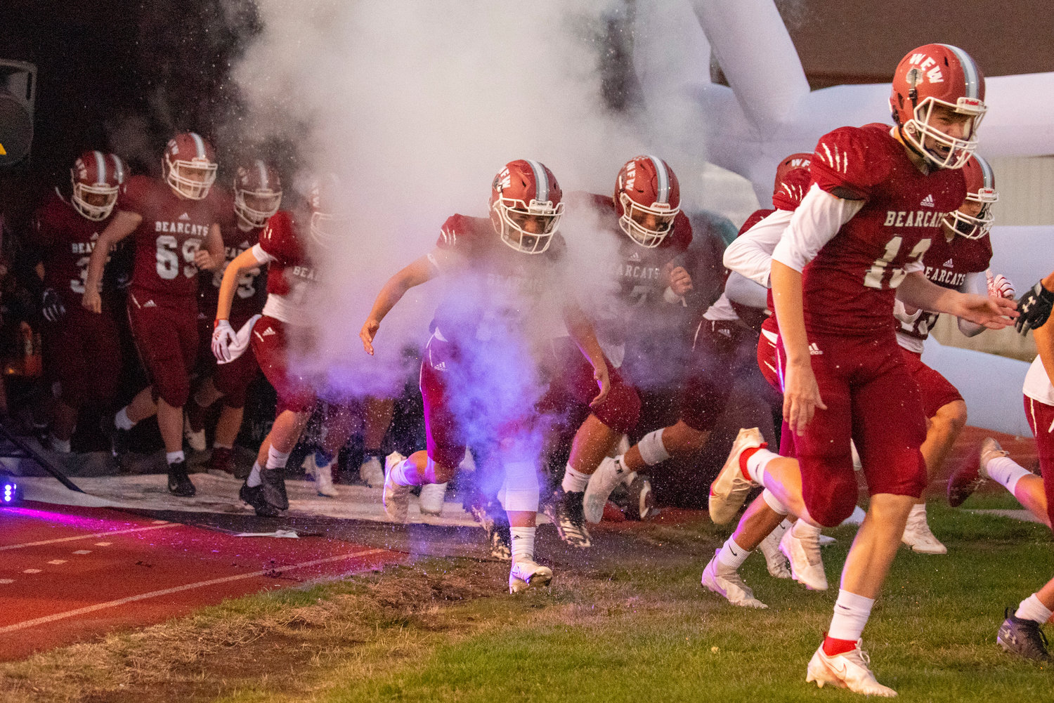 W.F. West football players sprint out of their giant helmet to take on visiting Rochester on Oct. 8, 2021.