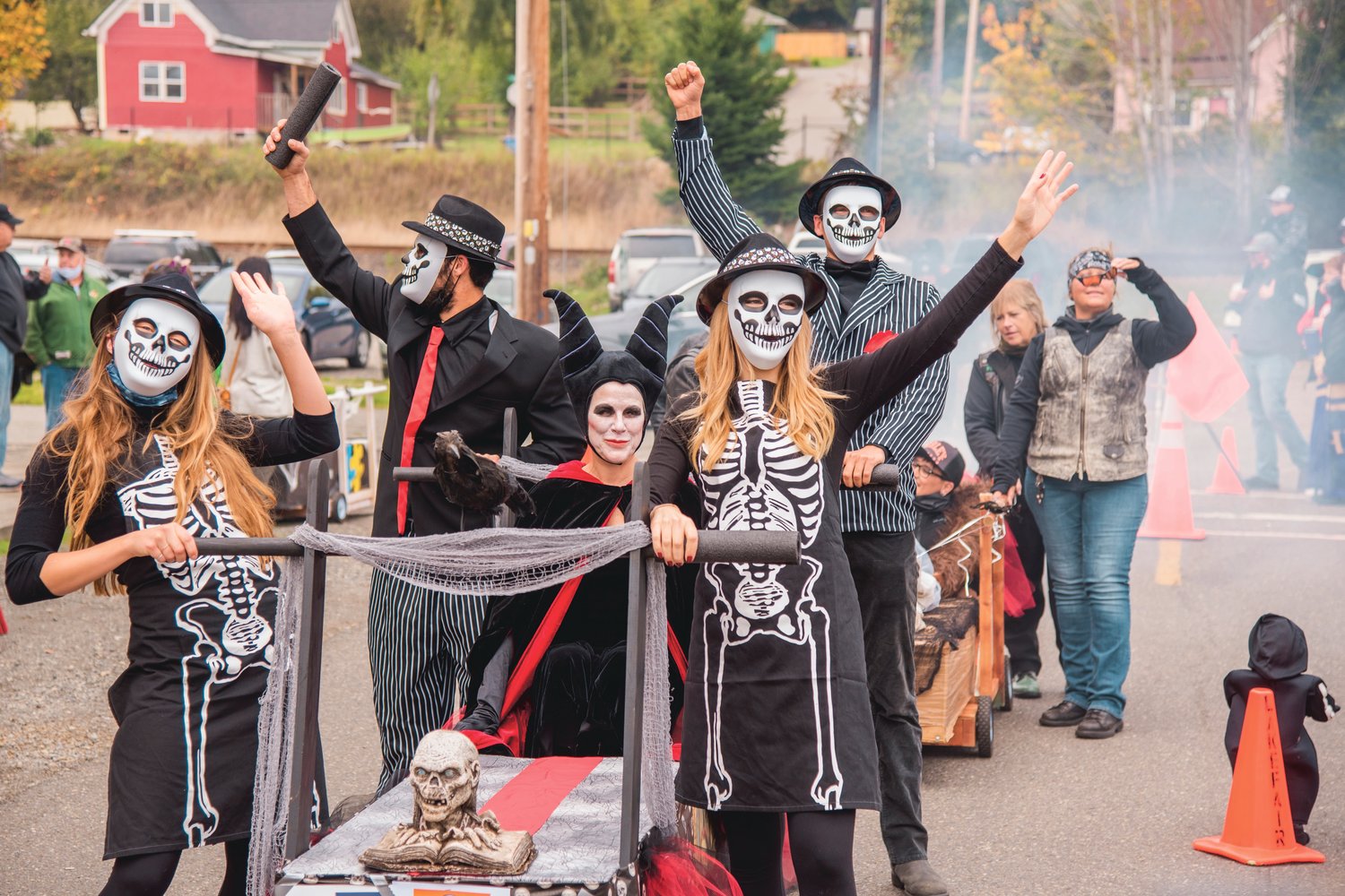 Olympia Mayor Cheryl Selby, riding center dressed as Maleficent, along with her City of Olympia crewmates wave during the Casket Parade outside Bucoda Town Hall Saturday afternoon before receiving the best dressed award.