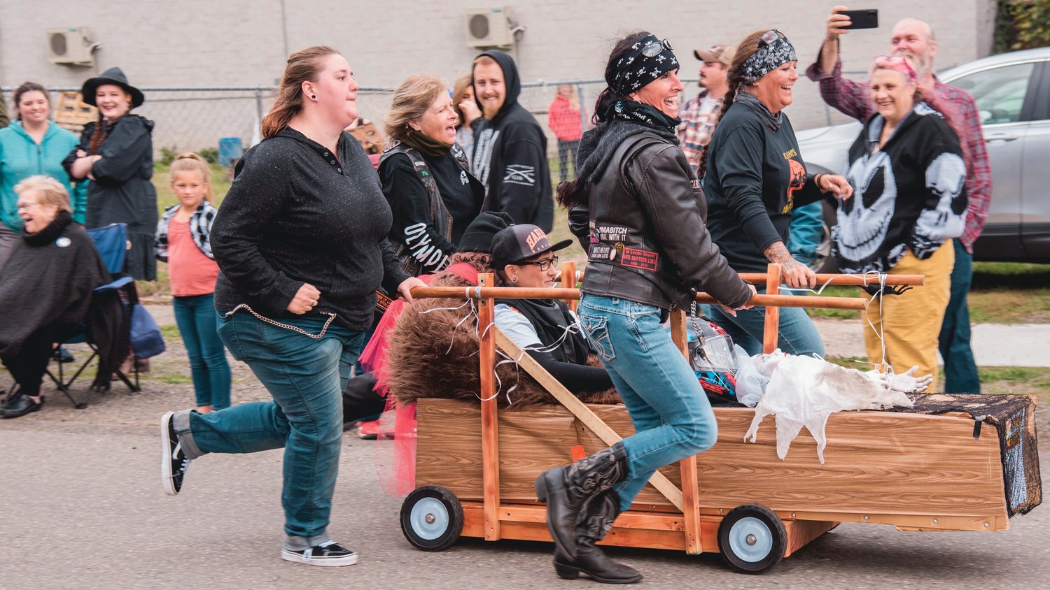 The Litas roll with their pine box during Casket Races Saturday afternoon in Boo-coda.