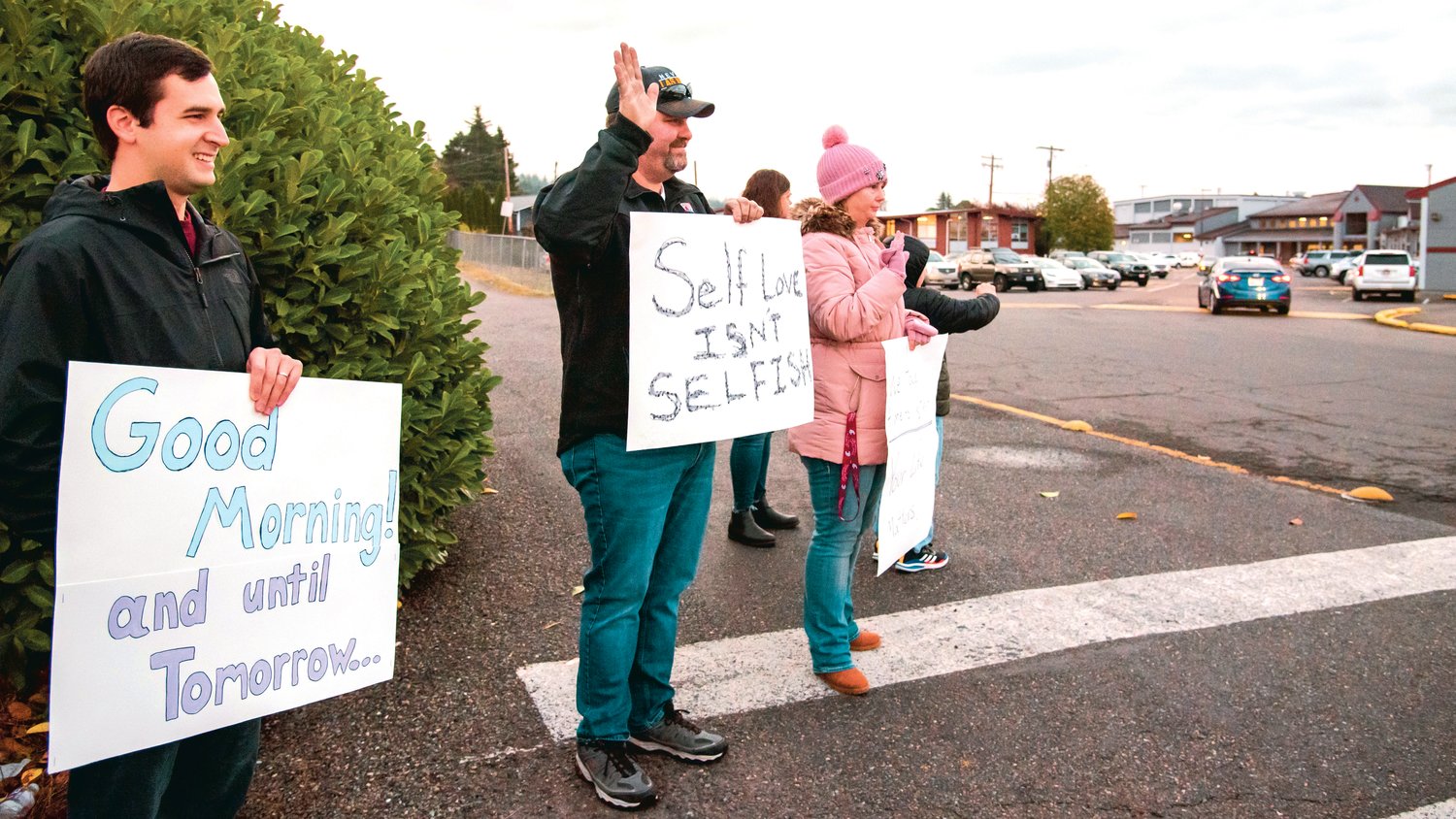 Signs displaying supportive messages are held at the entrance to W.F. West High School Monday morning in Chehalis.