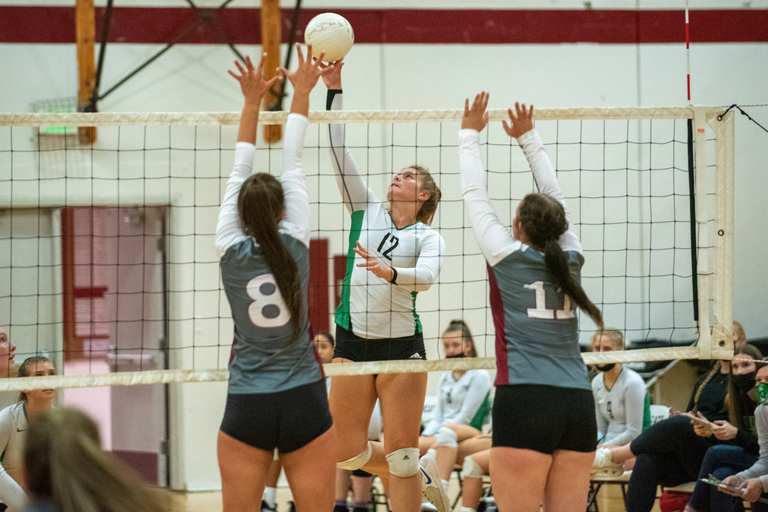 Tumwater's Madison Hurley (12) tips a ball over against W.F. West's Anna White (8) and Savannah Hawkins (11) on Oct. 14, 2021.