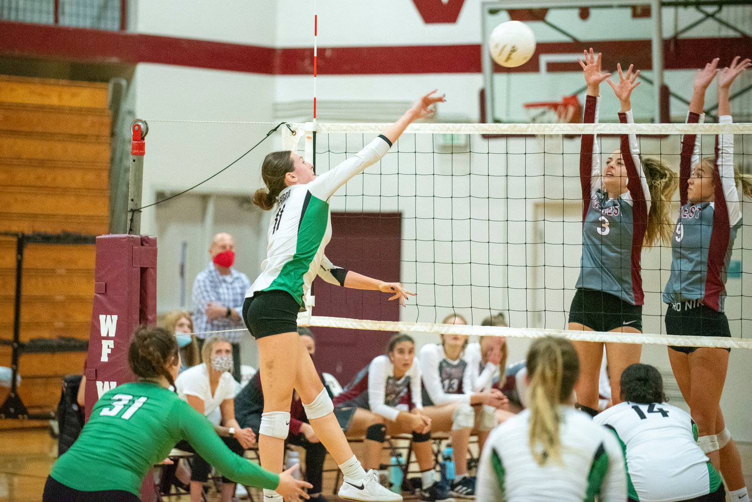 Tumwater's Kira Turcotte (11) throws down a spike against W.F. West's Amelia Etue (3) and Ava Olsen (9) on Oct. 14, 2021.