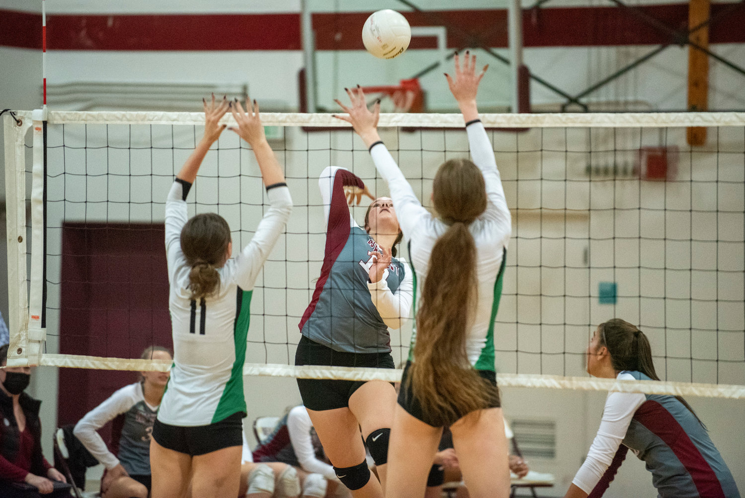W.F. West's Savannah Hawkins (11) spikes against two Tumwater blockers on Oct. 14, 2021.