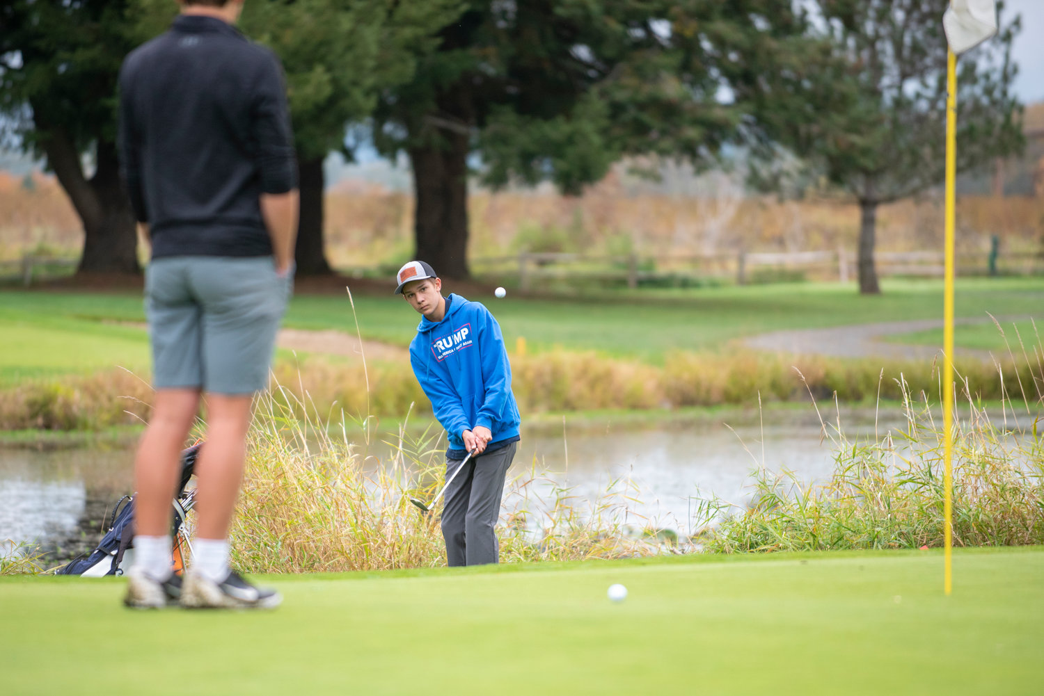 Black Hills' Luke Fenner chips a shot near the 17th hole during the 2A Evergreen Conference championships at Riverside Golf Course on Oct. 18, 2021.