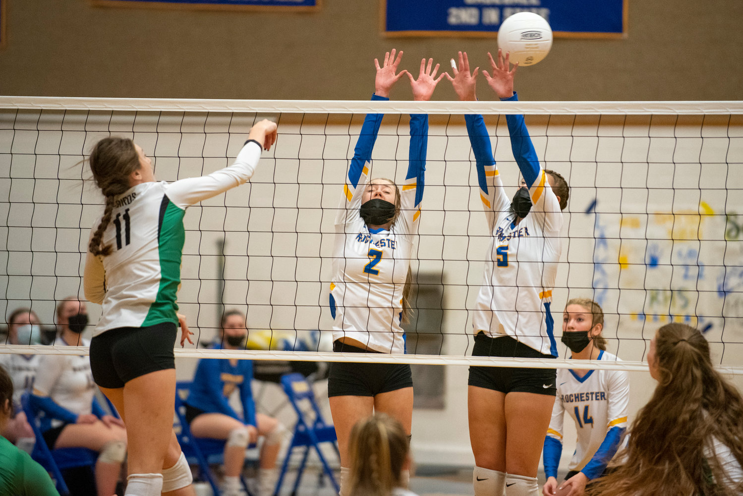 Tumwater's Kira Turcotte (11) leaps for a spike against Rochester's Kassidy Byrd (2) and Roisin Stull (5) during a 2A Evergreen Conference match in Rochester on Oct. 19, 2021.