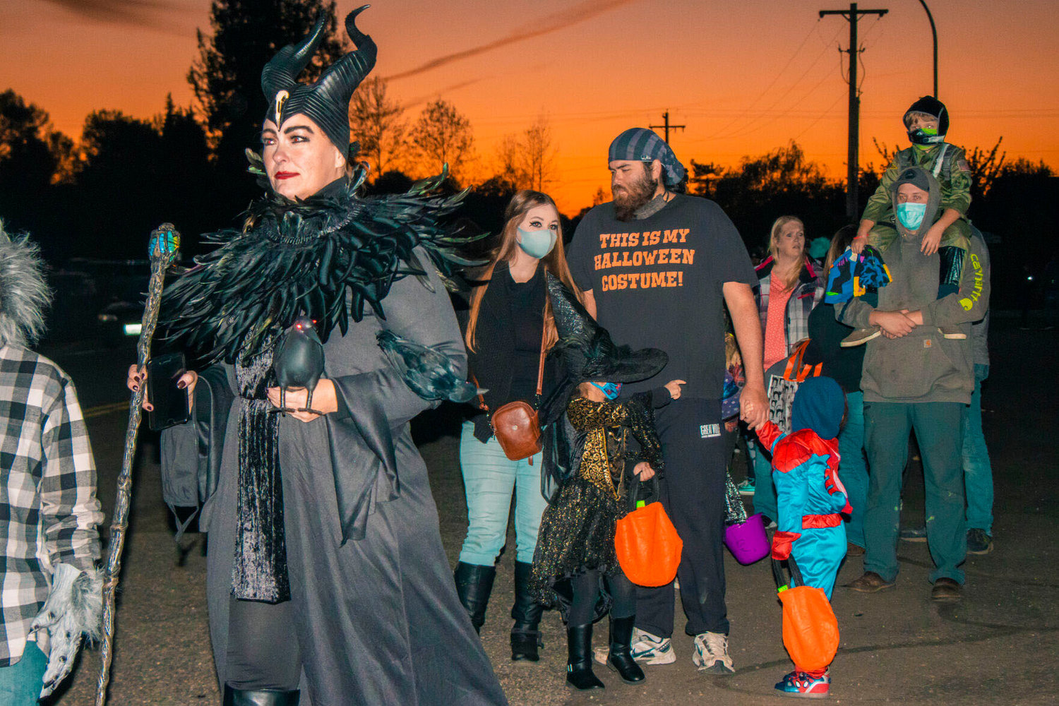 Community members decked out in Halloween attire wait in line for a trunk-or-treat event at the Veterans Memorial Museum on Halloween 2020.