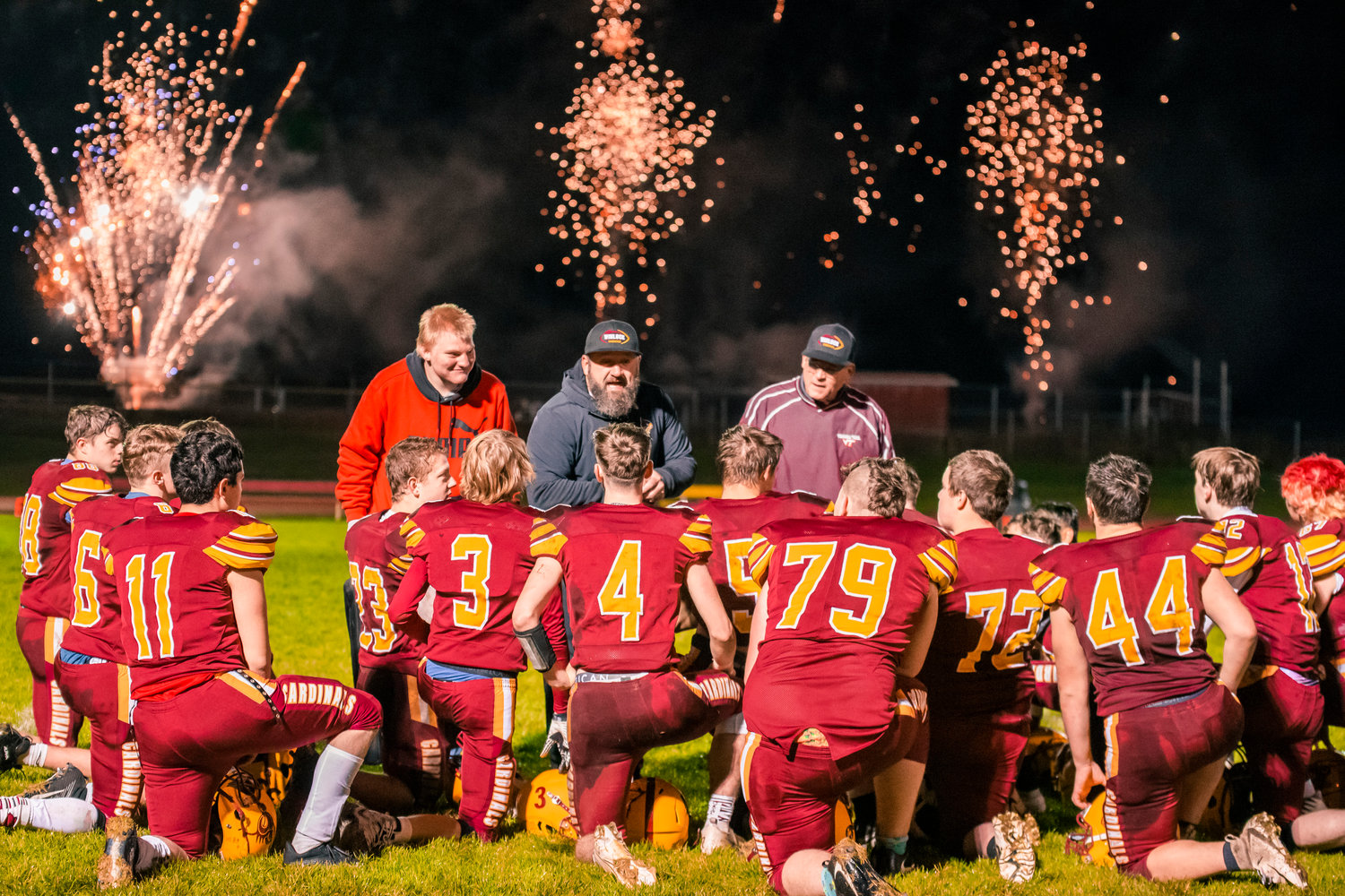 Winlock coaches congratulate players after a shutout as a show put on by Jake’s Fireworks Warehouse erupts near the field Friday for Senior Night.