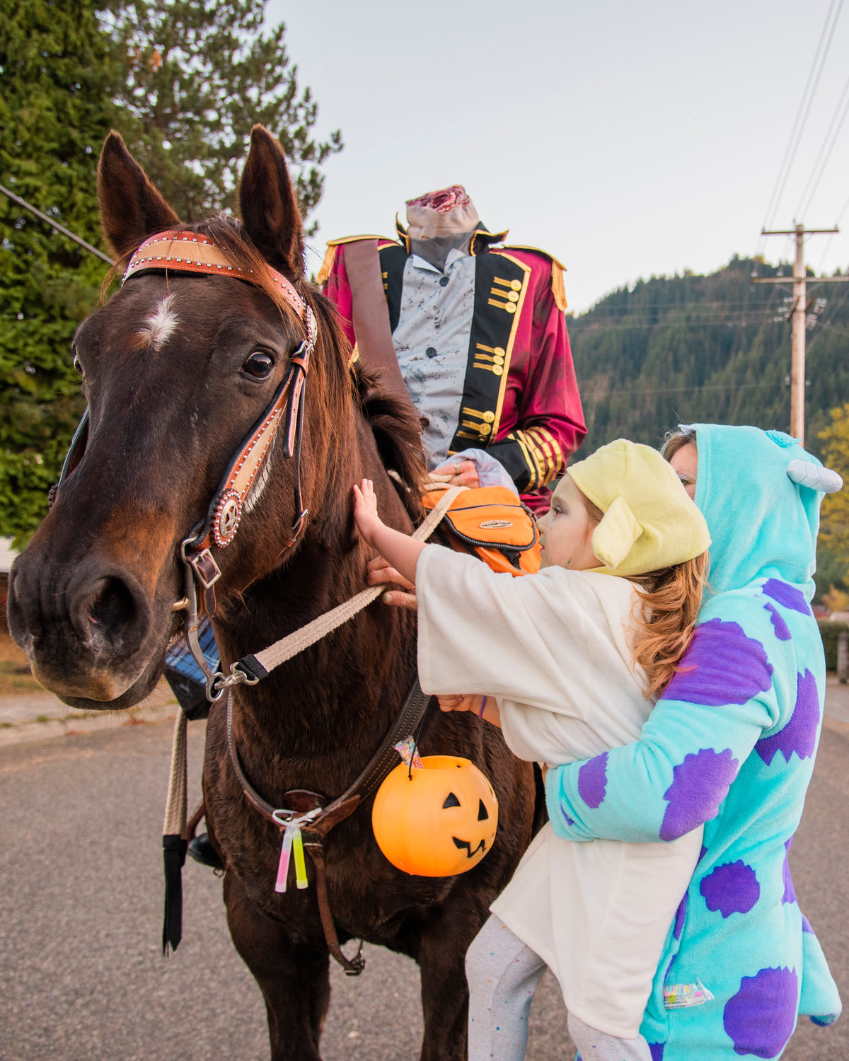 Girls sport costumes as they come up to pet Tallulah Jane after receiving candy from Bobbie Dalton, the Headless Horseman, in Morton on Halloween.