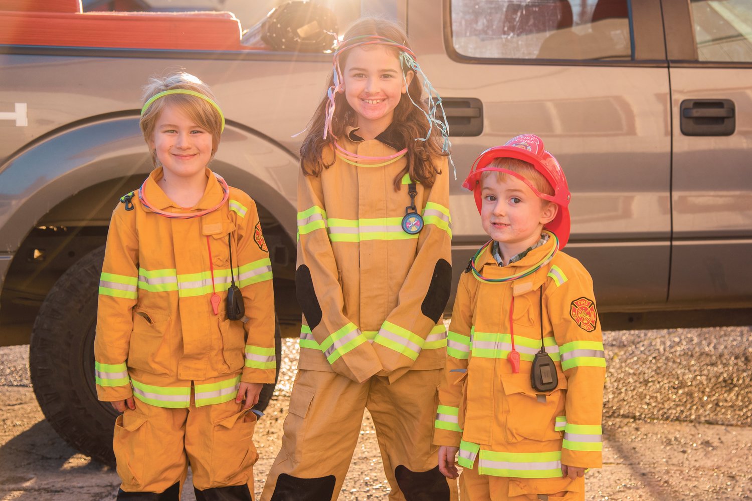 From left, Quinton, 6, Savannah, 8, and Grayson, 3, pose for a photo while dressed in firefighter coats outside the Lewis County Fire District #4 Haunted House in Morton on Halloween.