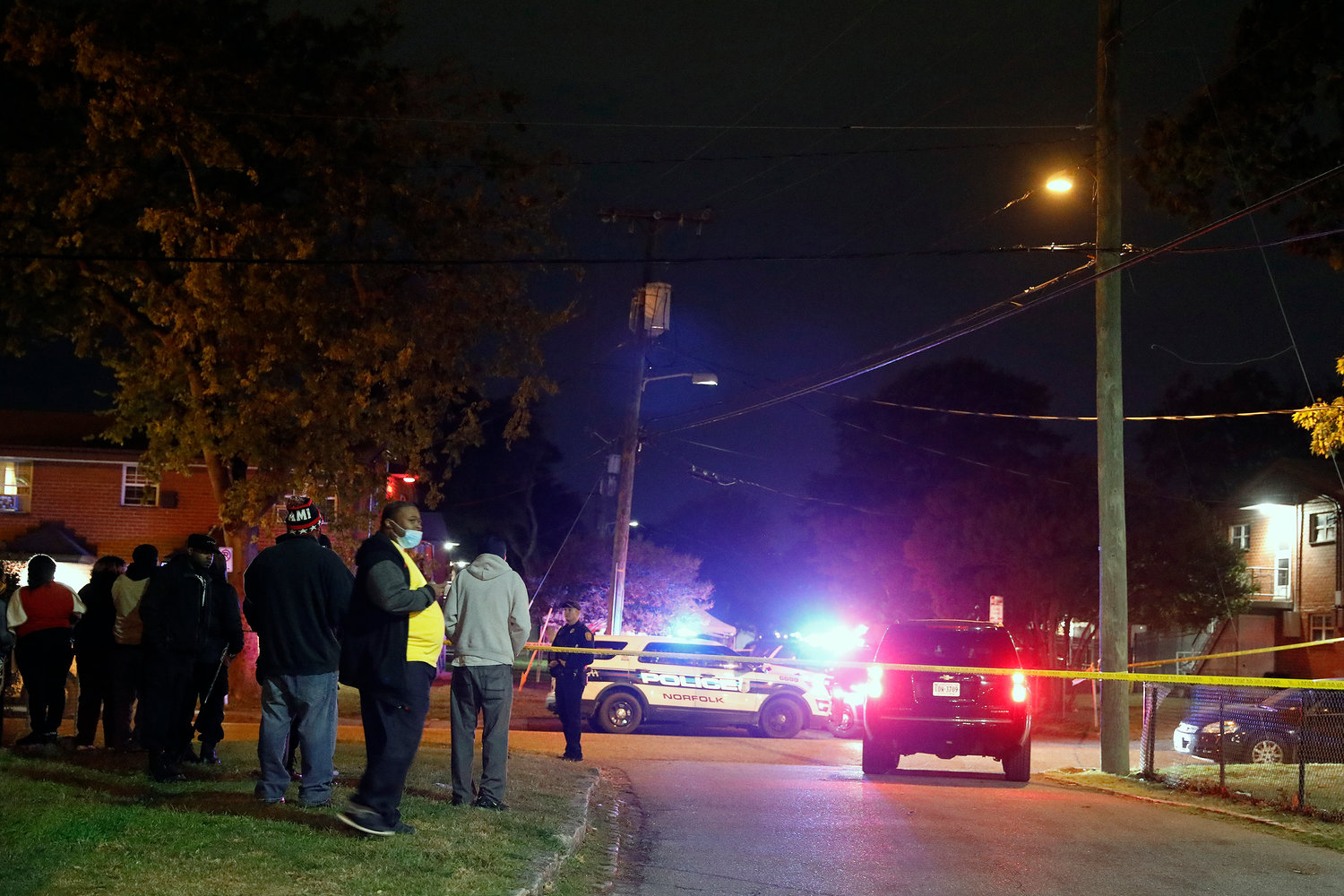 A crowd gathers as Norfolk police officers respond to the scene of a shooting in the Young Terrace neighborhood of Norfolk, Virginia on Wednesday, Nov. 3, 2021. (Jonathon Gruenke/The Virginian-Pilot/TNS)