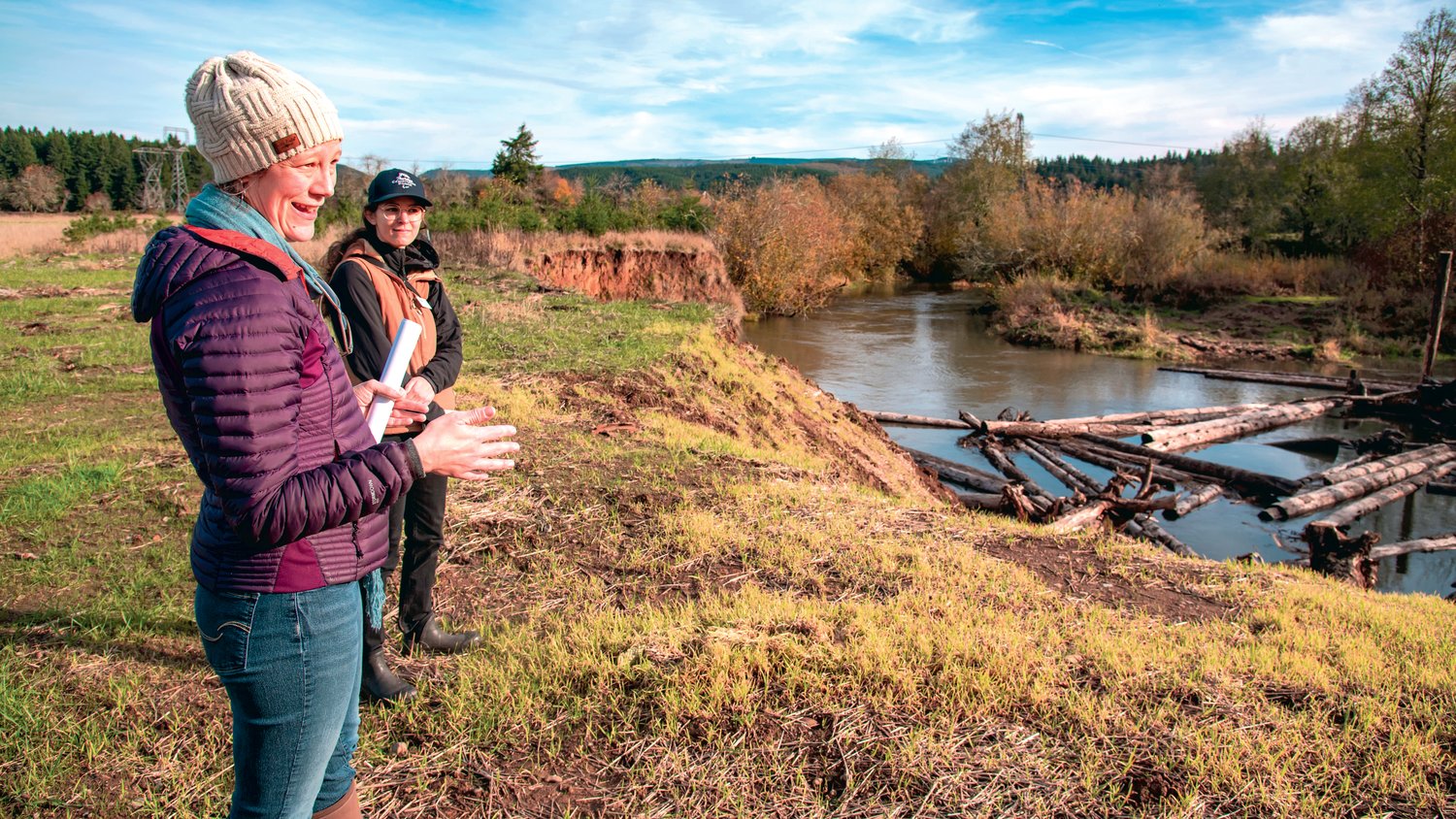 Chehalis Basin Strategy Manager Celina Abercrombie, left, and Mara Healy, a habitat specialist with the Thurston Conservation District, stand near the bank of the Skookumchuck River in Tenino on Monday talking about a Chehalis Basin restoration project.