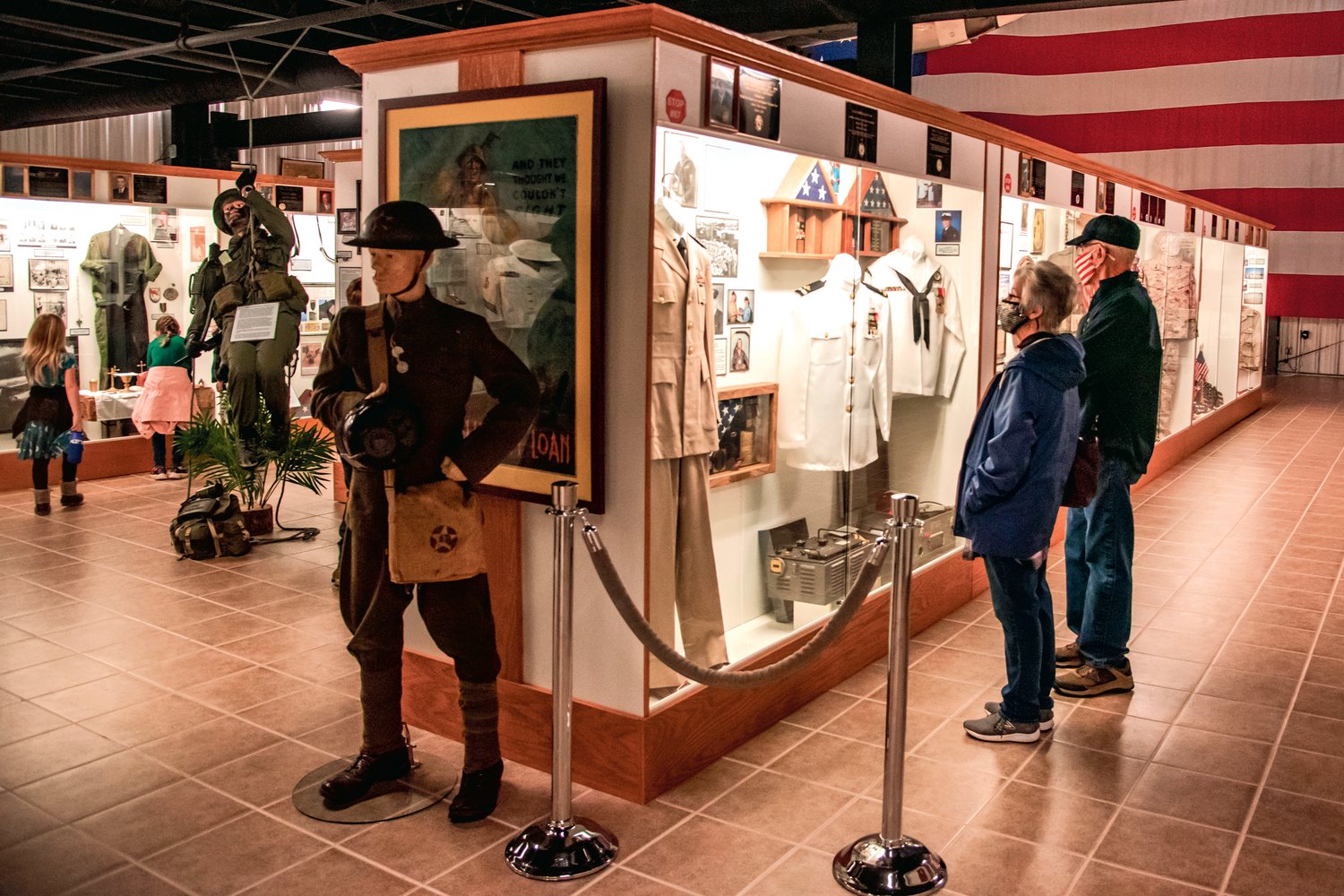 Visitors at the Veterans Memorial Museum look at military uniforms and equipment on display Thursday on Veterans Day in Chehalis.