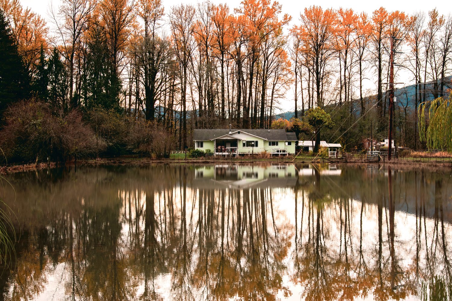 The reflection of a home and trees is seen in floodwaters as the Cowlitz River recedes Saturday in Randle.