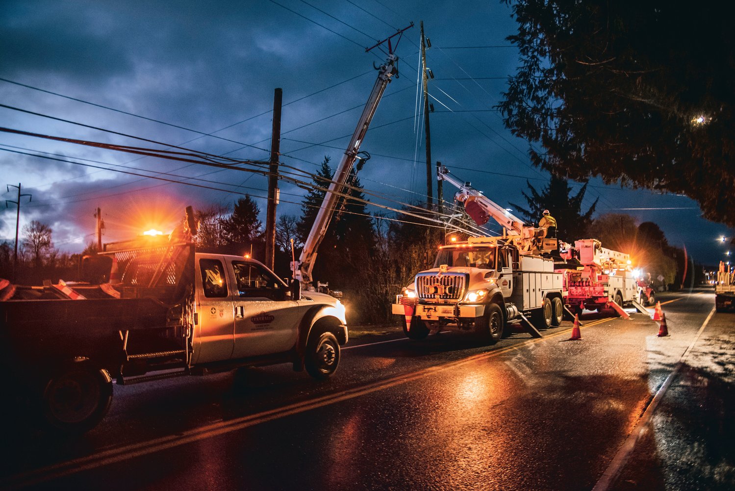 Centralia City Light employees and others work to repair a power pole in the 1500 block of North Pearl Street in Centralia after it was struck by a vehicle.