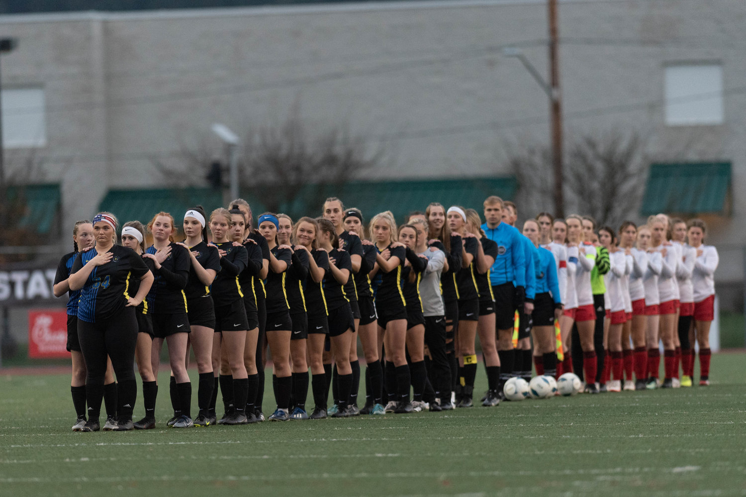 The Adna and Toledo girls soccer teams face the flag for the national anthem in the 2B state semifinals Nov. 19.