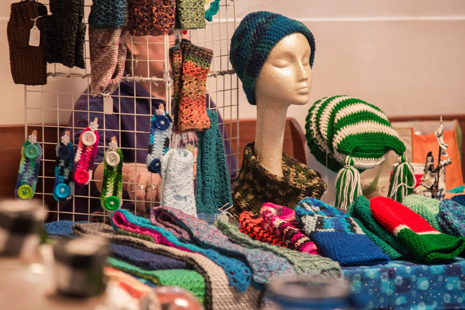 Scarves, beanies and other knitted items are displayed inside the Adna Grange Hall on tables and racks Saturday afternoon during a Fall Bazaar.