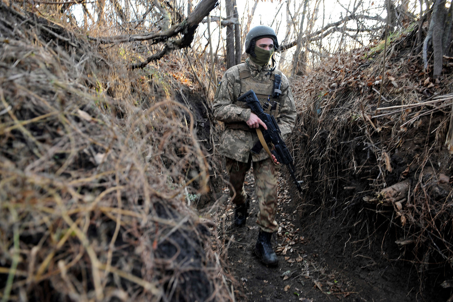 A Ukrainian serviceman walks along a trench on the frontline with Russia-backed separatists near the village of Talakivka, Donetsk region, on Wednesday, Nov. 24, 2021. (Sergey Volskiy/AFP/Getty Images/TNS)