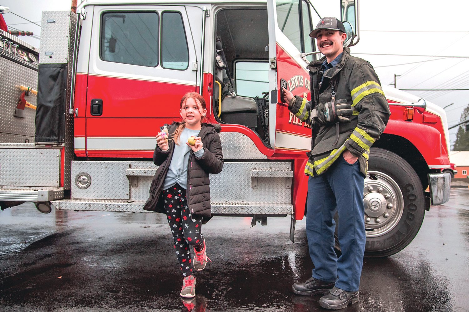 Savannah, a third grader at Napavine Grade School, smiles and poses for a photo with Tyler Correia of Lewis County Fire District 5 Monday in Napavine.