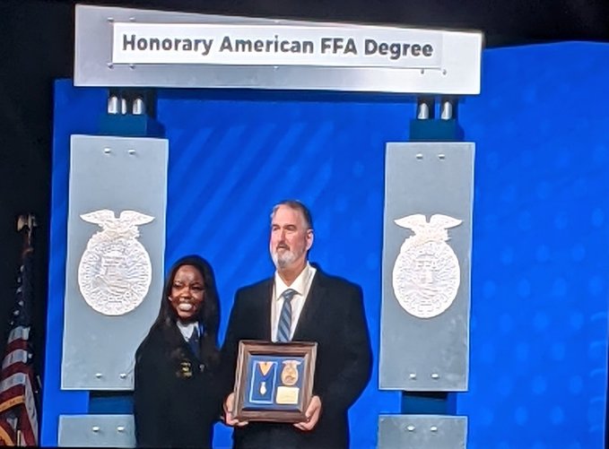 Outgoing National FFA Southern Region Vice President Artha Jonassaint presents Lloyd Walker with the Honorary American FFA Degree at the 94th National FFA Convention and Expo in late October.