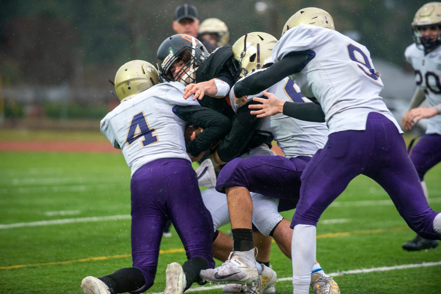 Onalaska defenders pile up on a Kalama ball carrier during the state semfinals Nov. 27.