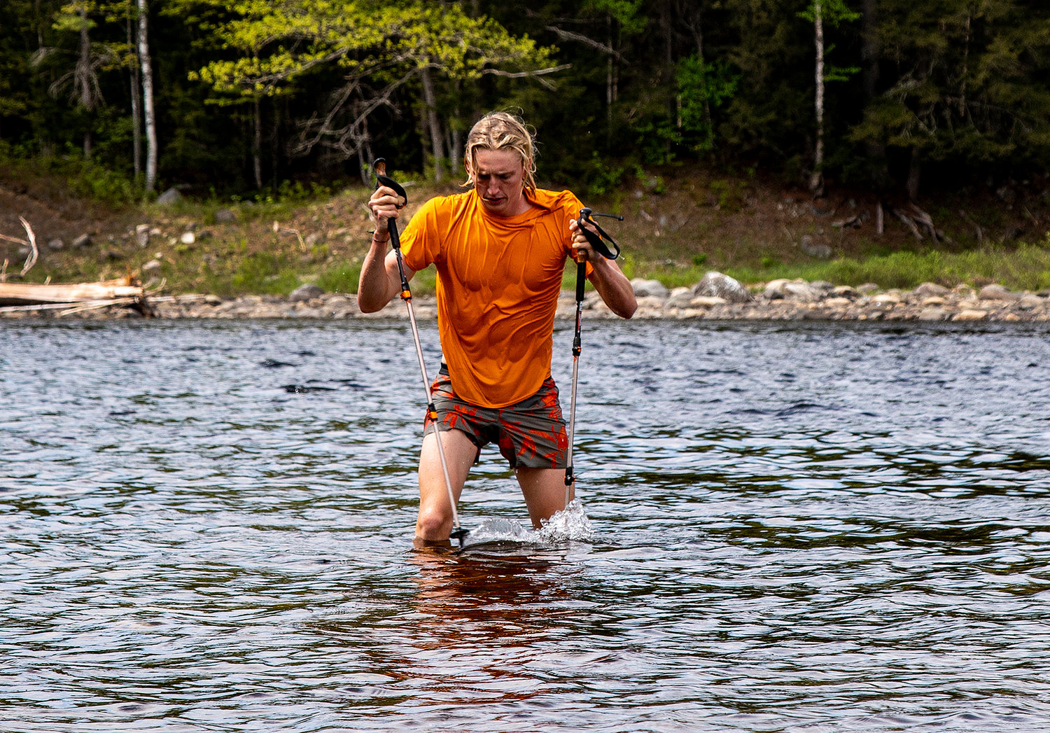 Jackson Parell of Florida emerges from the Kennebec River carrying his hiking poles after forgetting them on the other side of the river and having to swim back across to retrieve, along the Appalachian Trail on May 21, 2021, near Caratunk, Maine. (Gina Ferazzi/Los Angeles Times/TNS)