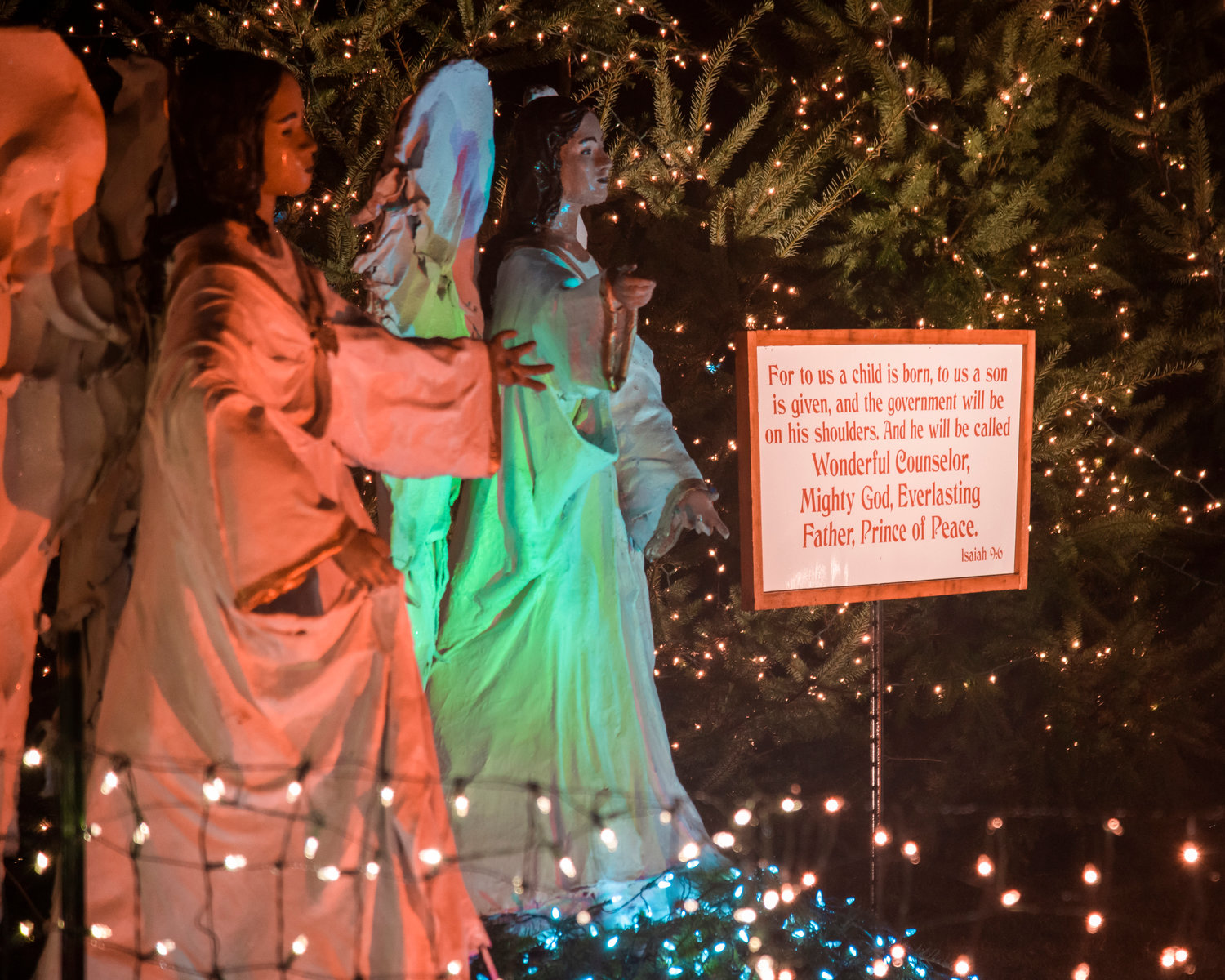Scriptures are displayed on signs near statues of angels with wings in motion during the Christmas Island Lighting Ceremony in Maytown on Saturday.