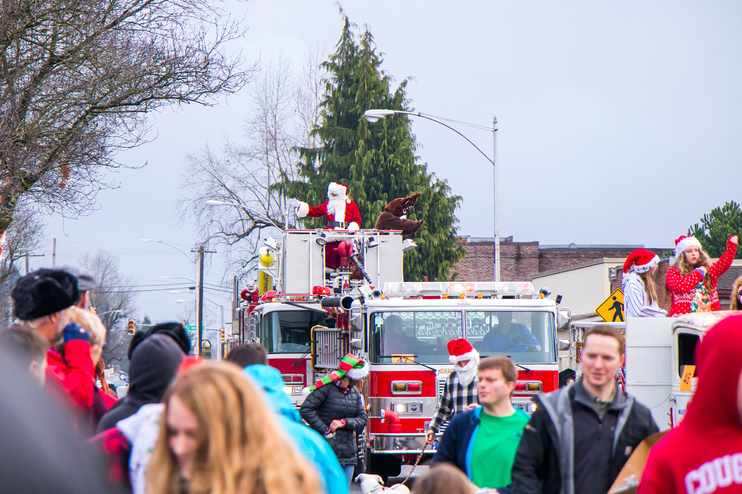 FILE PHOTO — Santa and Rudolph wave from the bucket of a Chehalis Fire truck as they make their way downtown in Chehalis in 2019.