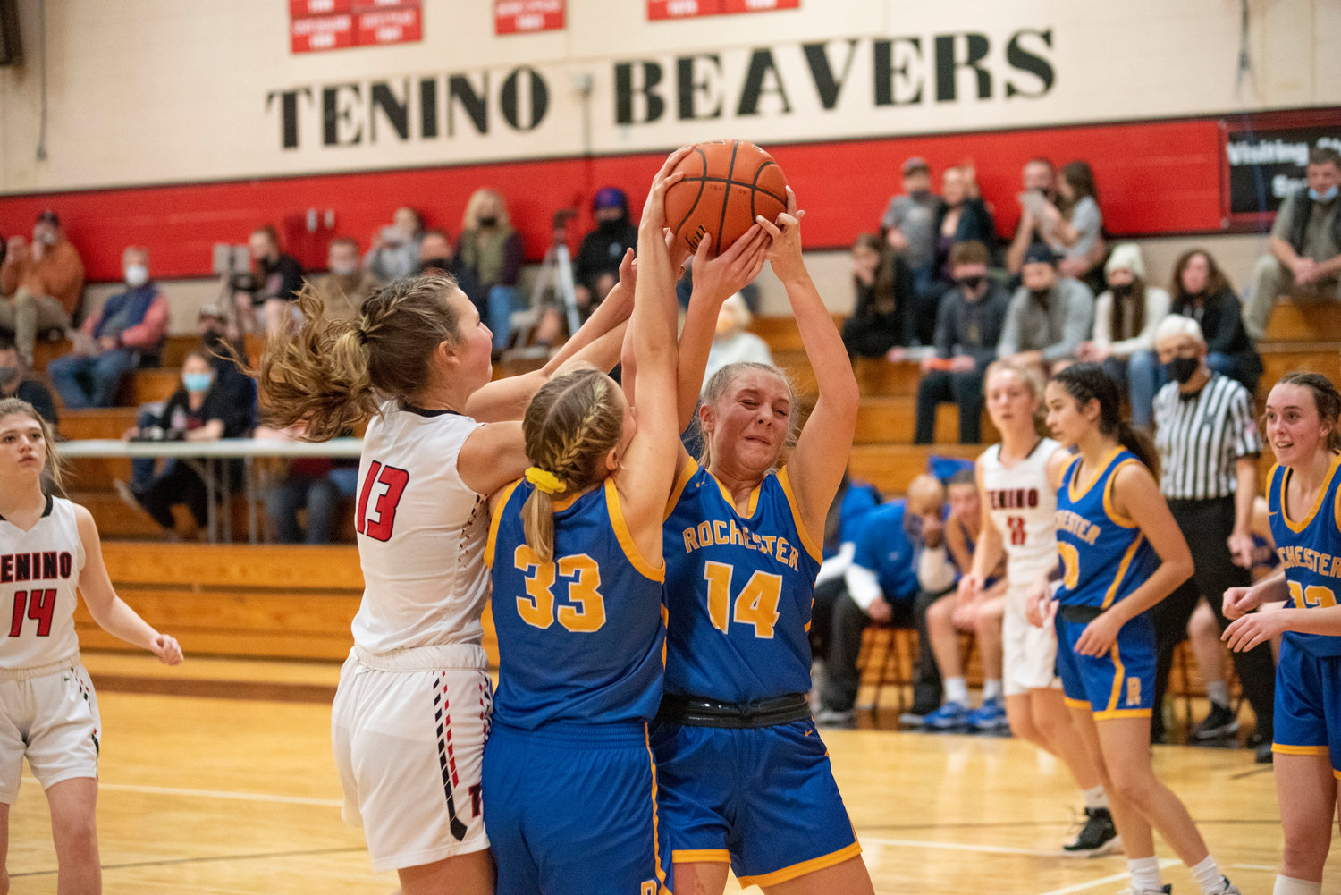 Rochester's Hailey Angwood (14), Hannah Rodeheaver (33) and Tenino's Rilee Jones (13) battle for a rebound on Dec. 2.