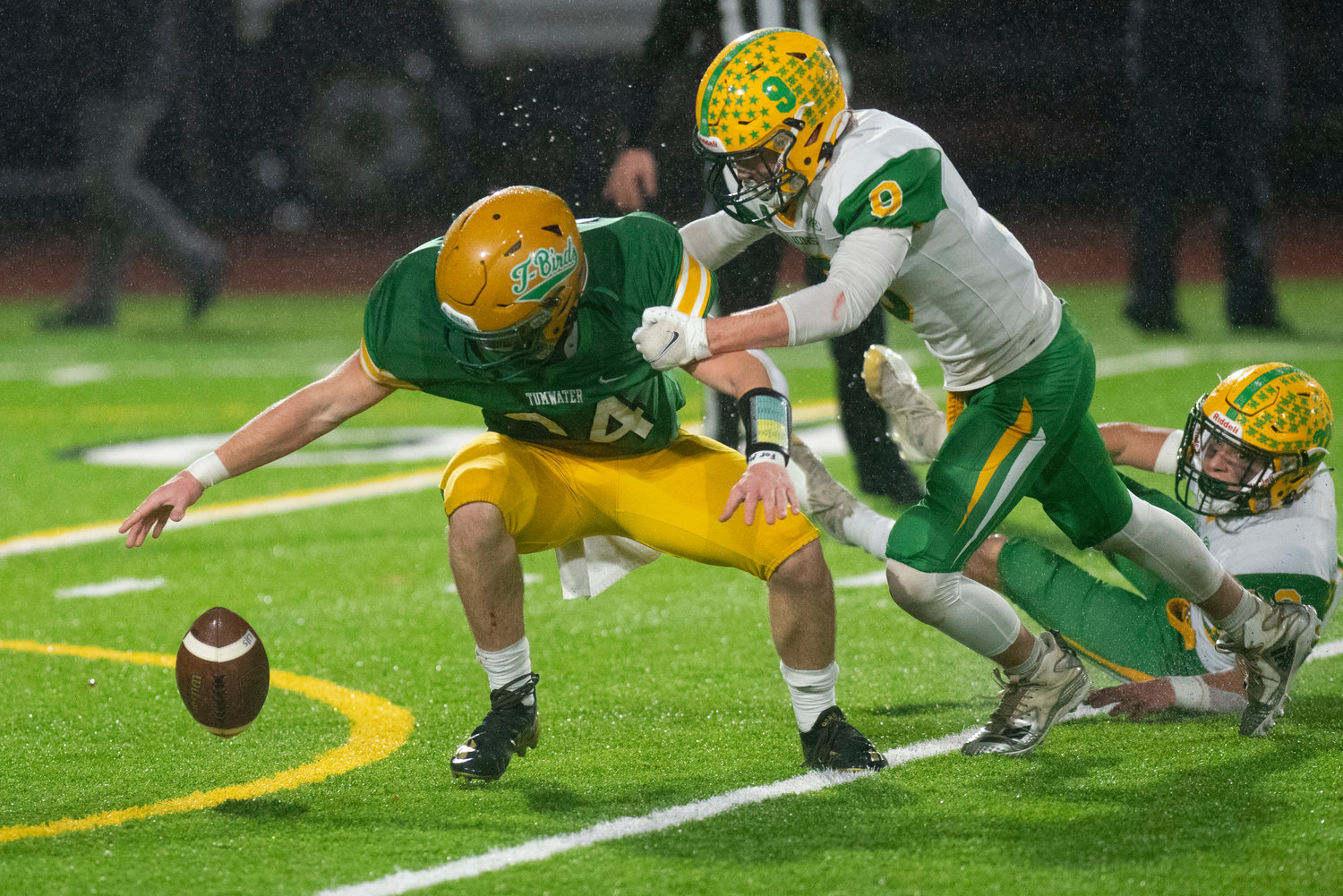 Tumwater’s Payton Hoyt looks to corral a Lynden punt as Lynden’s Ryan Kleindel (9) hits him during the 2A state title game on Dec. 4.