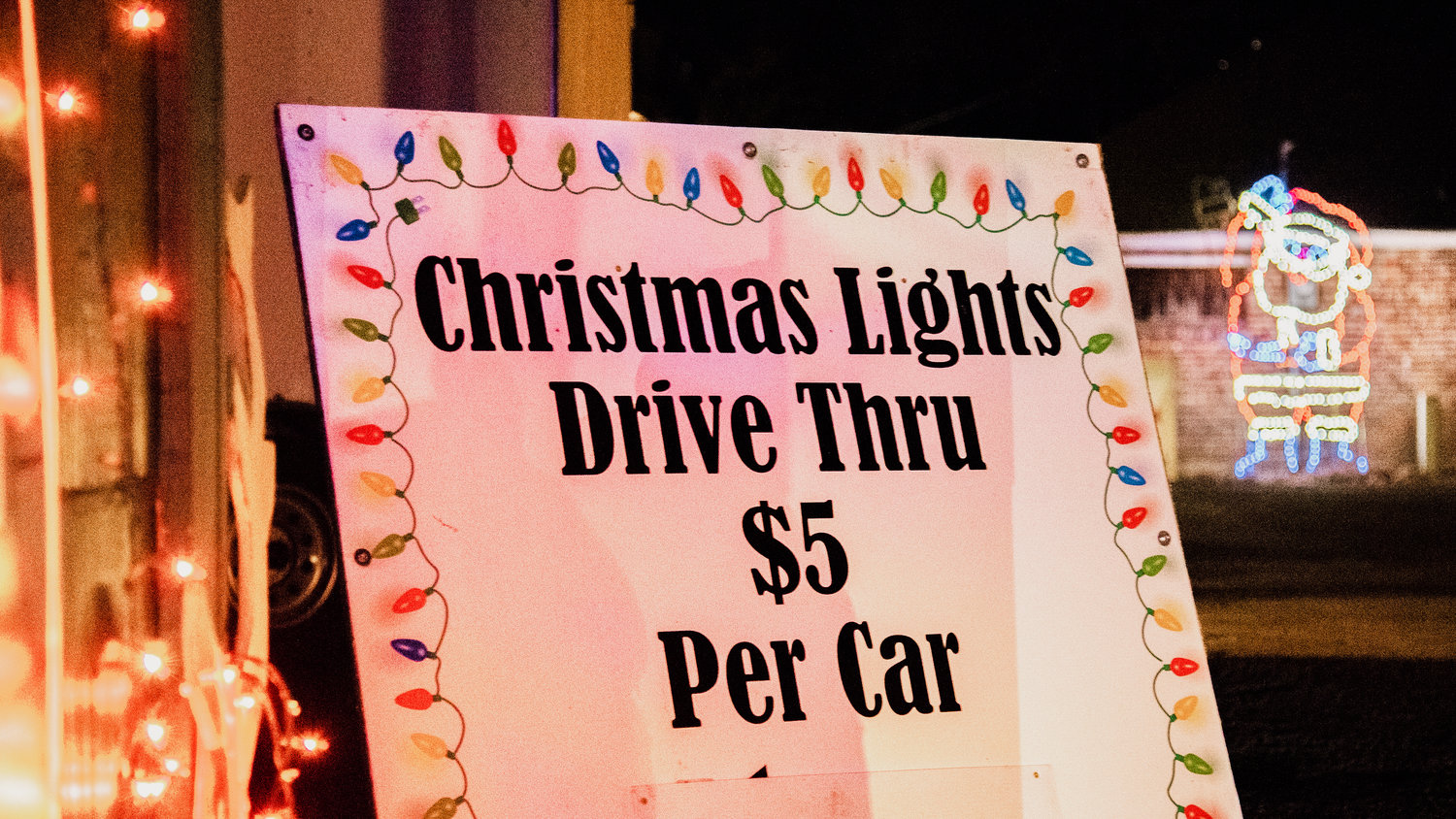 A sign sits at the entrance of Fort Borst Park where for $5 vehicles can cruise through an array of lights along a pathway around the park listening to Christmas tunes.