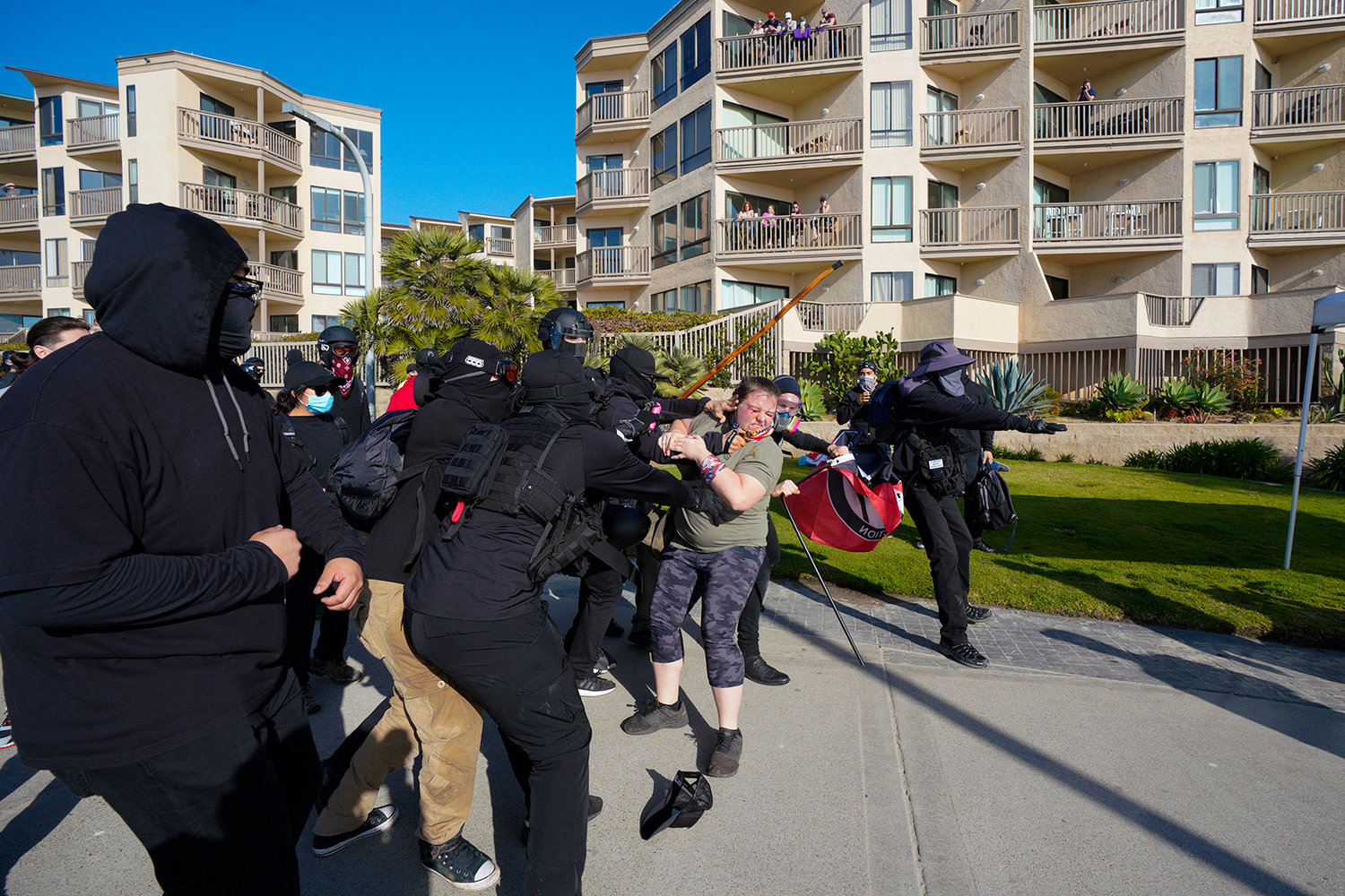 In this Jan. 9, 2021, file photo, black-clad counterprotesters fight with a woman on the boardwalk south of Crystal Pier in Pacific Beach in San Diego, California during a pro-Trump “Patriot March.” (Nelvin C. Cepeda/San Diego Union-Tribune/TNS)
