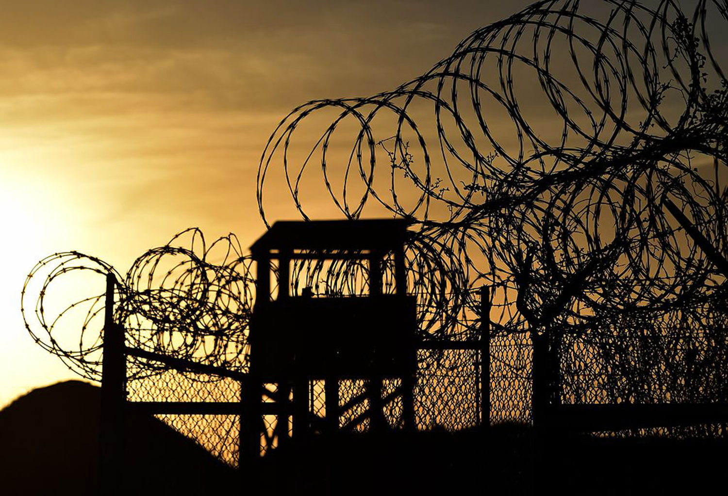 This photo made during an escorted visit and reviewed by the US military, shows the razor wire-topped fence and a watch tower at the abandoned "Camp X-Ray" detention facility at the US Naval Station in Guantanamo Bay, Cuba, April 9, 2014. (Mladen Antonov/AFP via Getty Images/TNS)