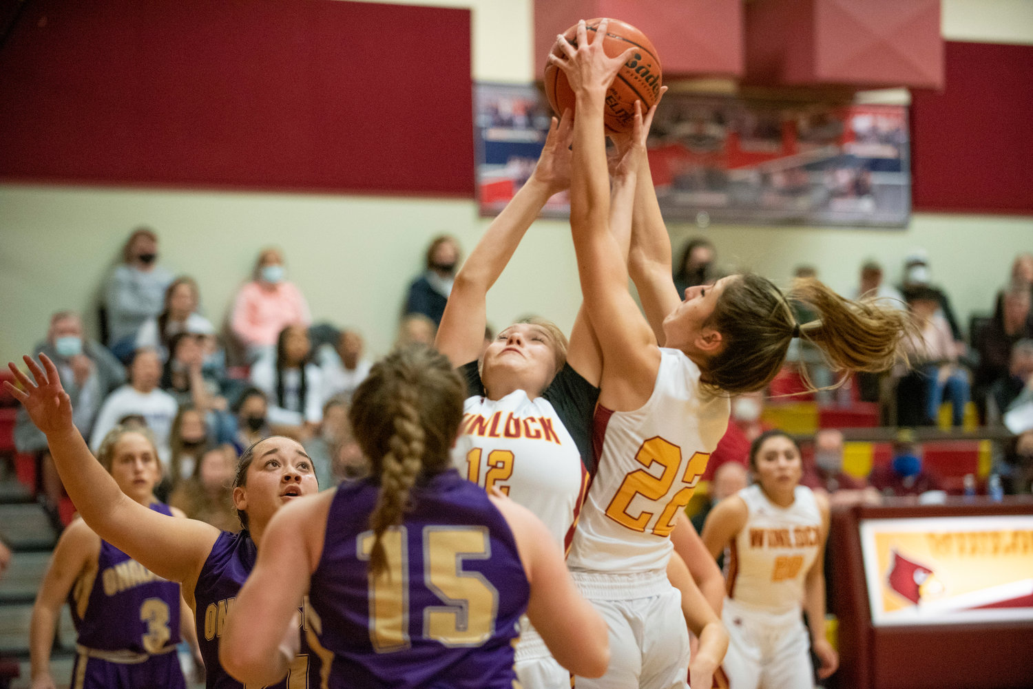 Winlock's Maia Chaney (12) and Charlie Carper (22) leap for a defensive rebound against Onalaska on Dec. 10..
