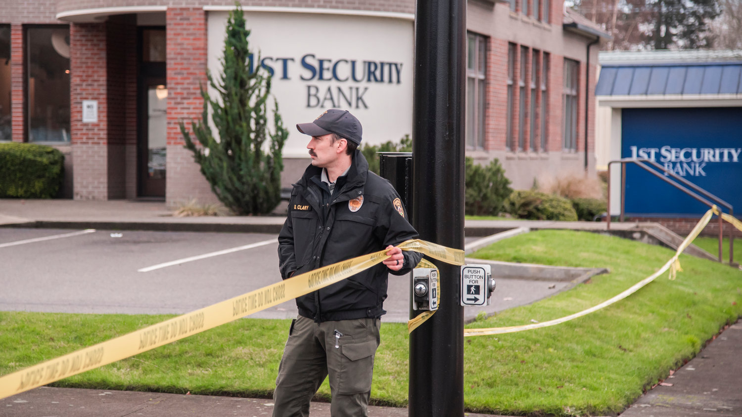 Detective Sergeant Dave Clary holds police line tape wrapped around 1st Security Bank in Centralia last month.