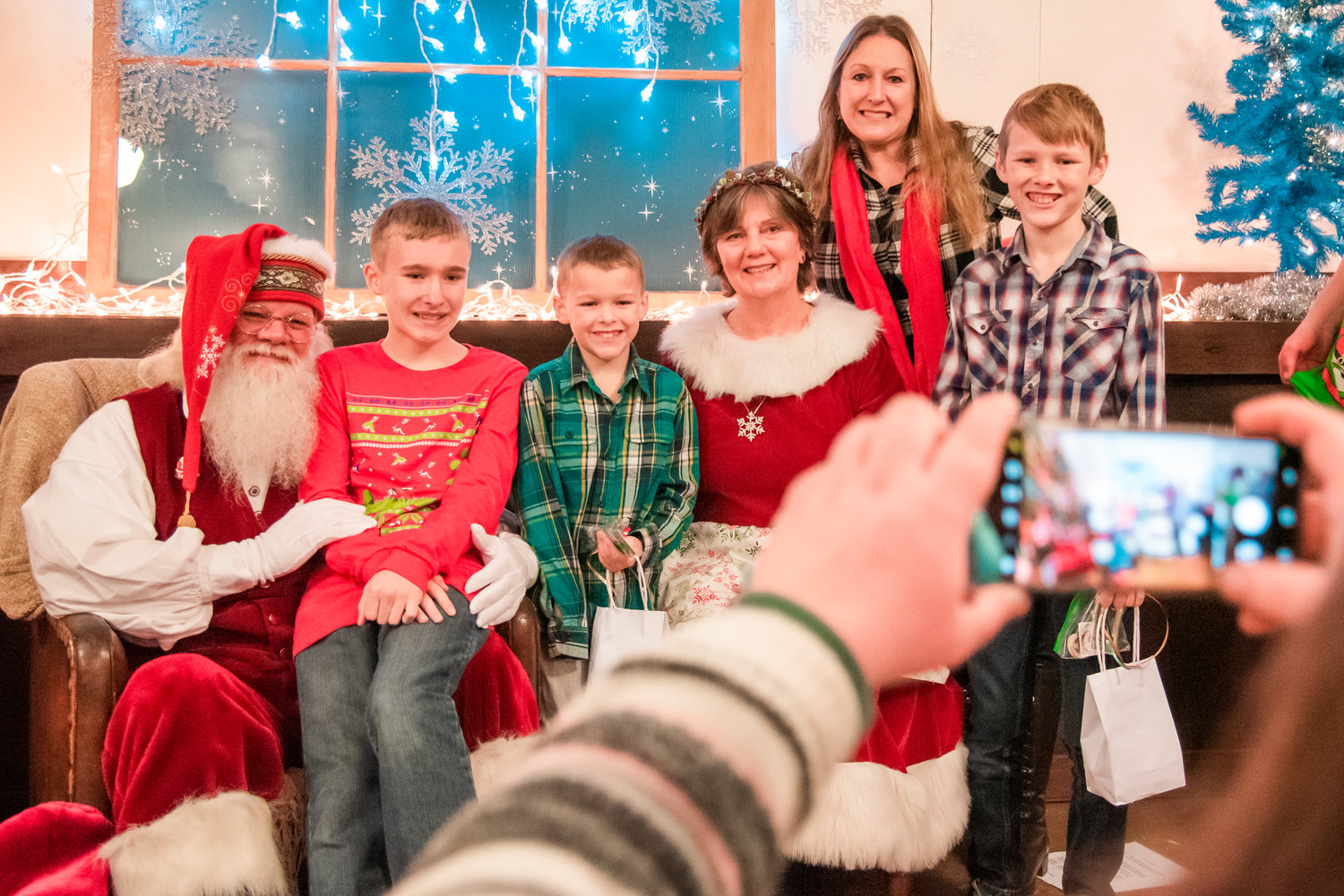 From left to right, Archer, Barrett, Raylan and Leah Freeman smile and pose for a photo with “Santa Tony Christen” and “Mrs. Laurie Claus” at the Newaukum Valley Schoolhouse during a Christmas program Sunday.