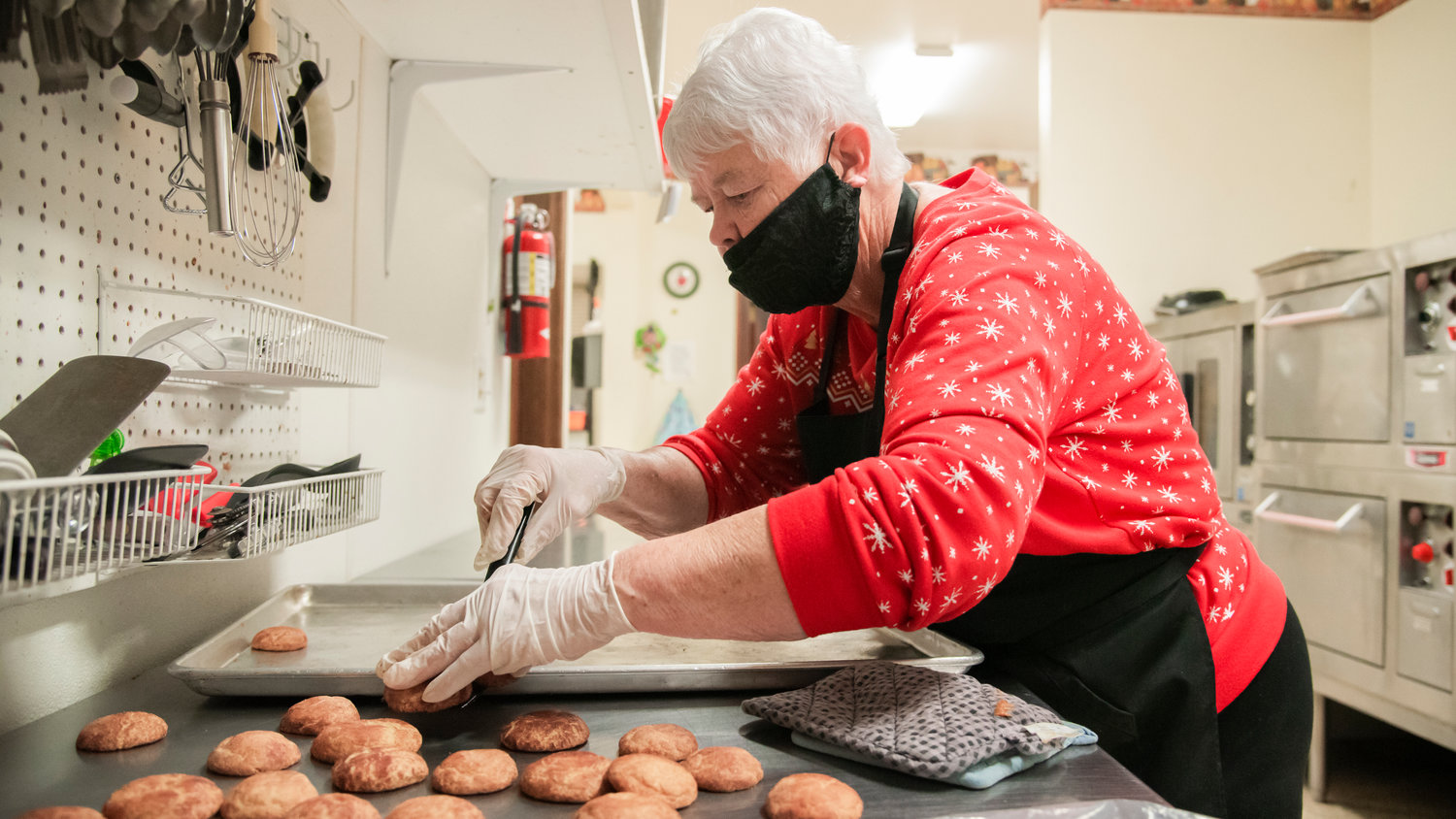 Debbie Mallow organizes snickerdoodle cookies after removing them from an oven at the Community Church of God in Centralia Saturday morning. With the help of volunteers, the Centralia church was aiming to bake 2,000 cookies to be handed out at the church.