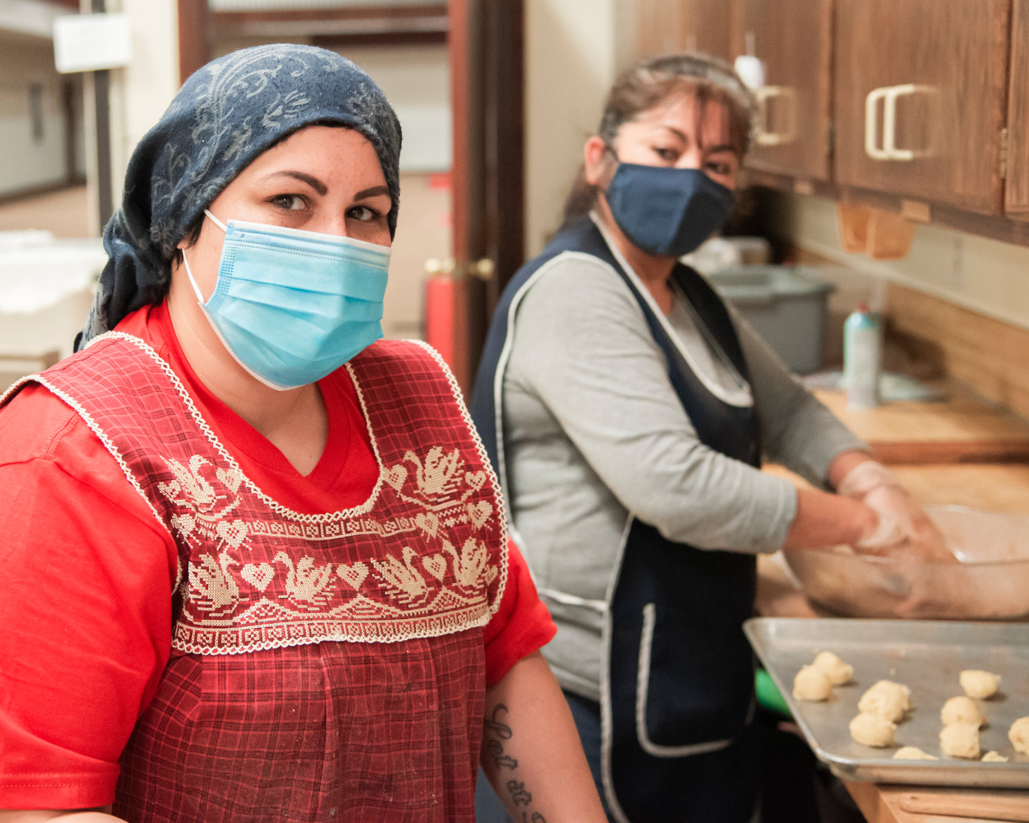 Natalia Velazquez and Elo Salgado roll balls of dough before they are put into the oven at the Community Church of God in Centralia Saturday morning.