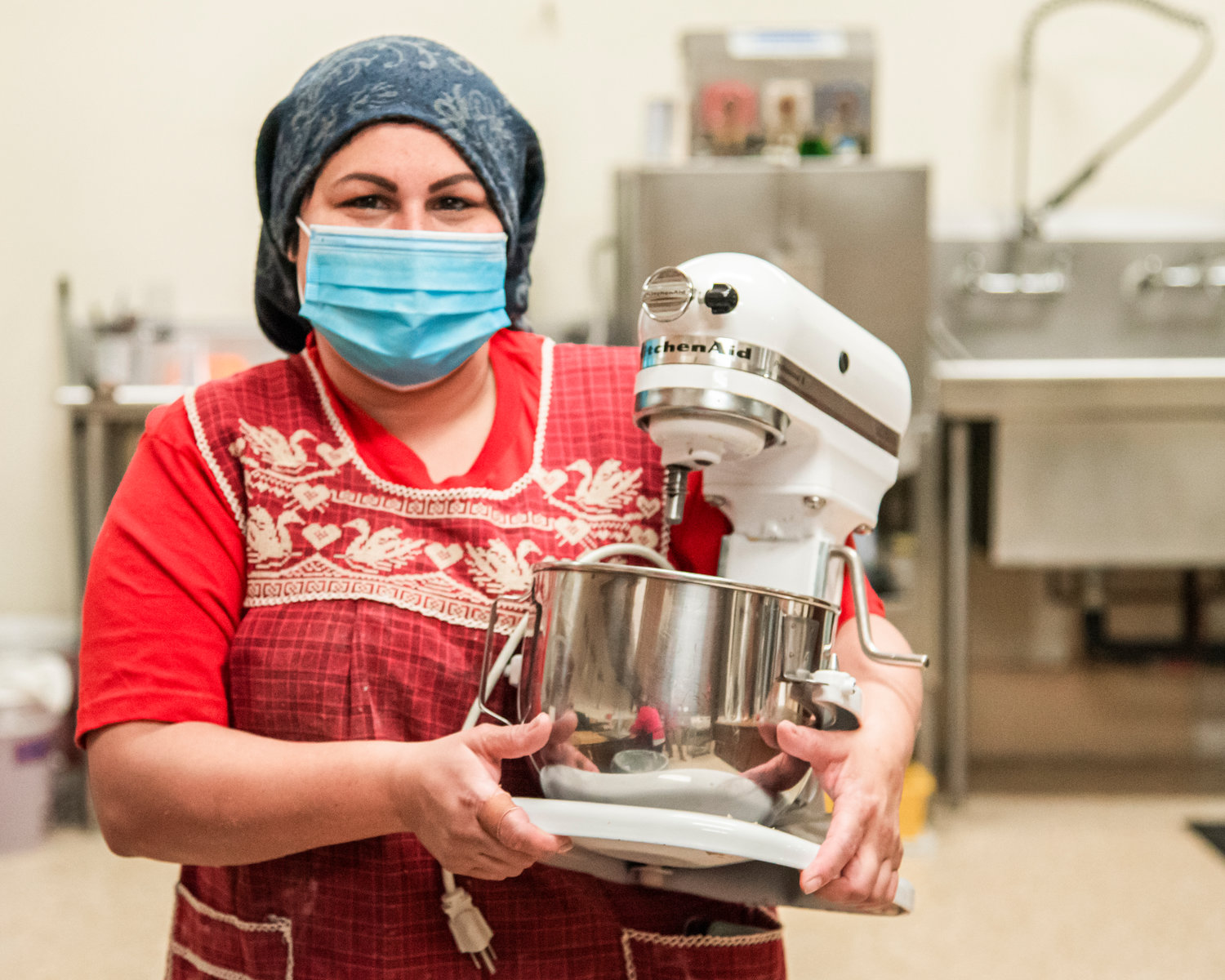 Natalia Velazquez carries a mixer through the kitchen while making cookies at the Community Church of God in Centralia Saturday afternoon.