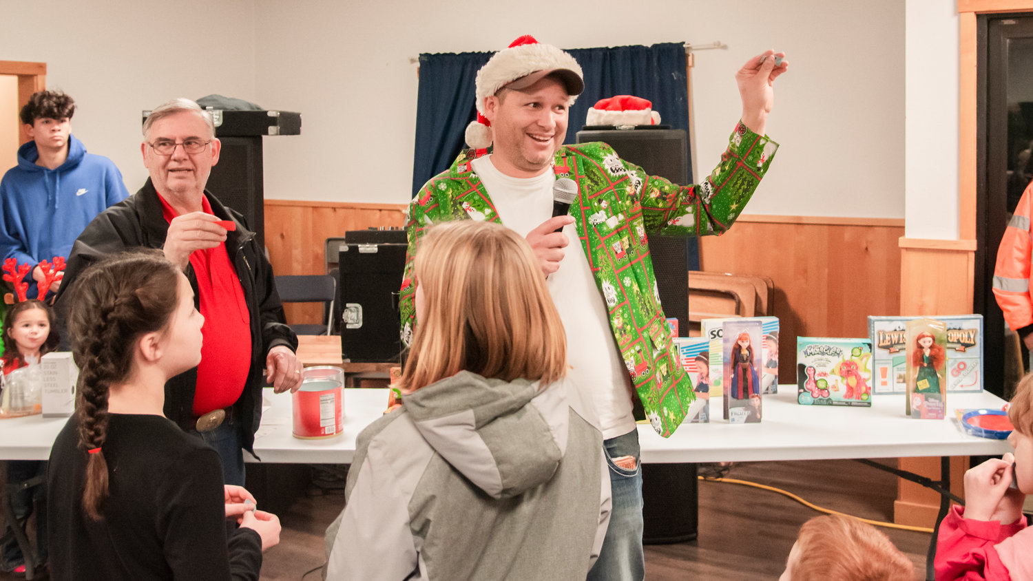 Mossyrock Mayor Randall Sasser and another man draw tickets for a gift raffle inside the Mossyrock Community Center during a tree lighting ceremony Saturday night.