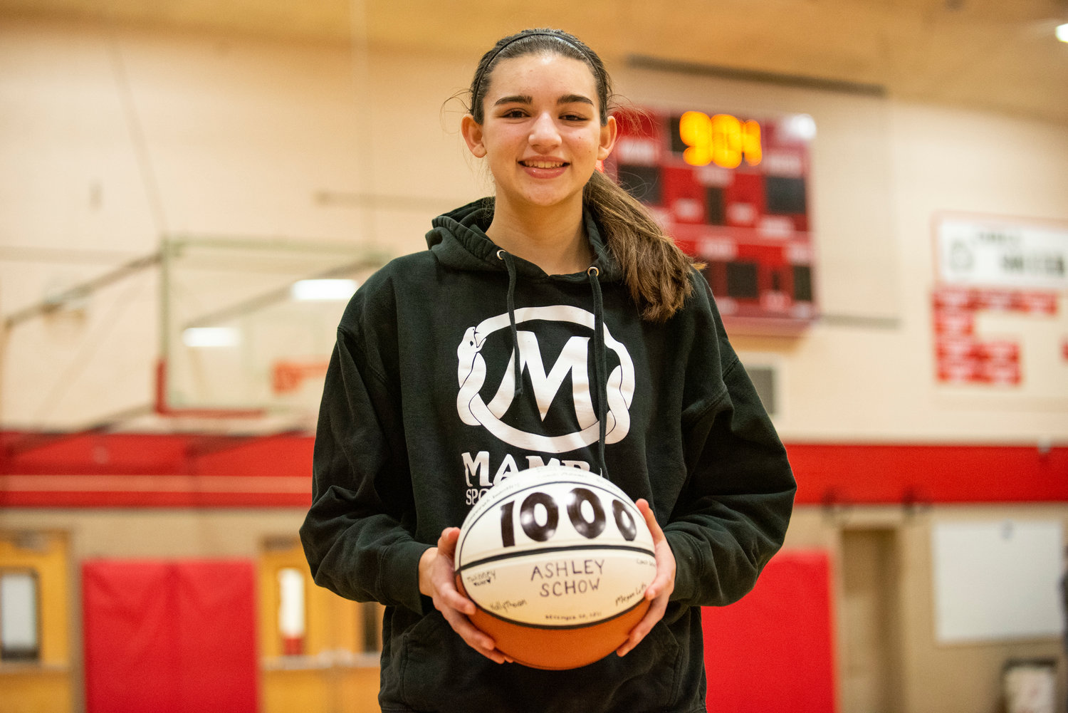 Tenino's Ashley Schow poses with her 1,000th-point ball after a home game against Cascade Christian on Dec. 20, 2021.