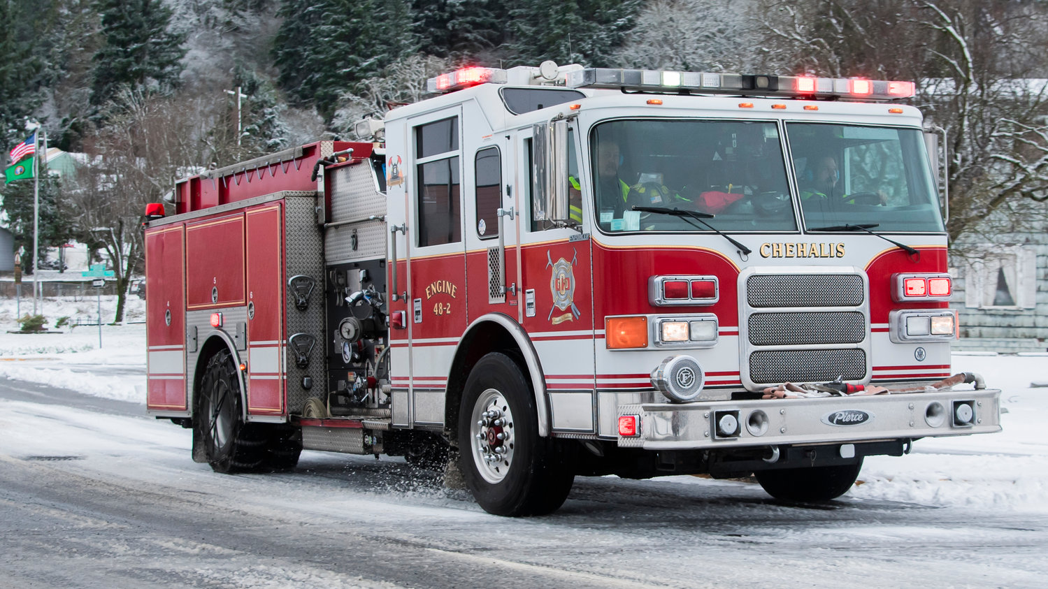 A fire engine drives through downtown Chehalis with lights illuminated Sunday morning.
