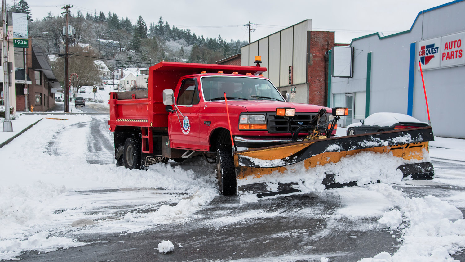 A Chehalis Public Works truck drives snow removal equipment along roadways Sunday morning.