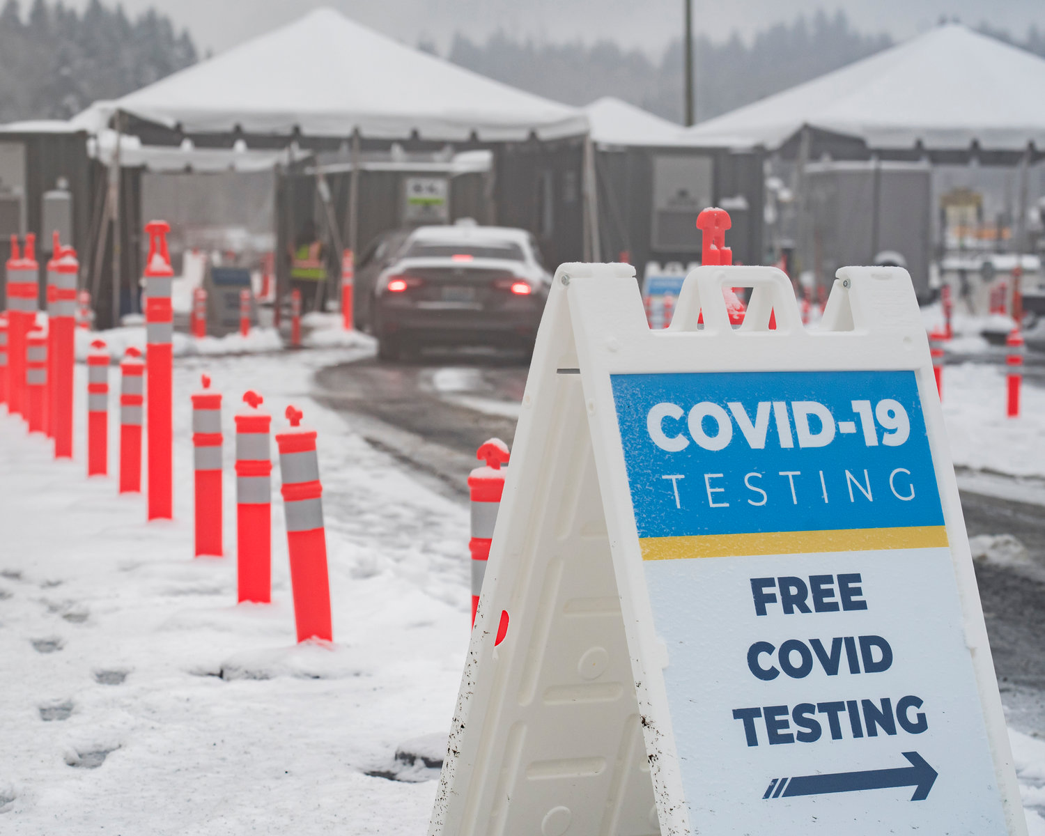 Signage for “Free COVID Testing” sits on display in a snow covered parking lot outside the Lewis County Mall in Chehalis on Tuesday.