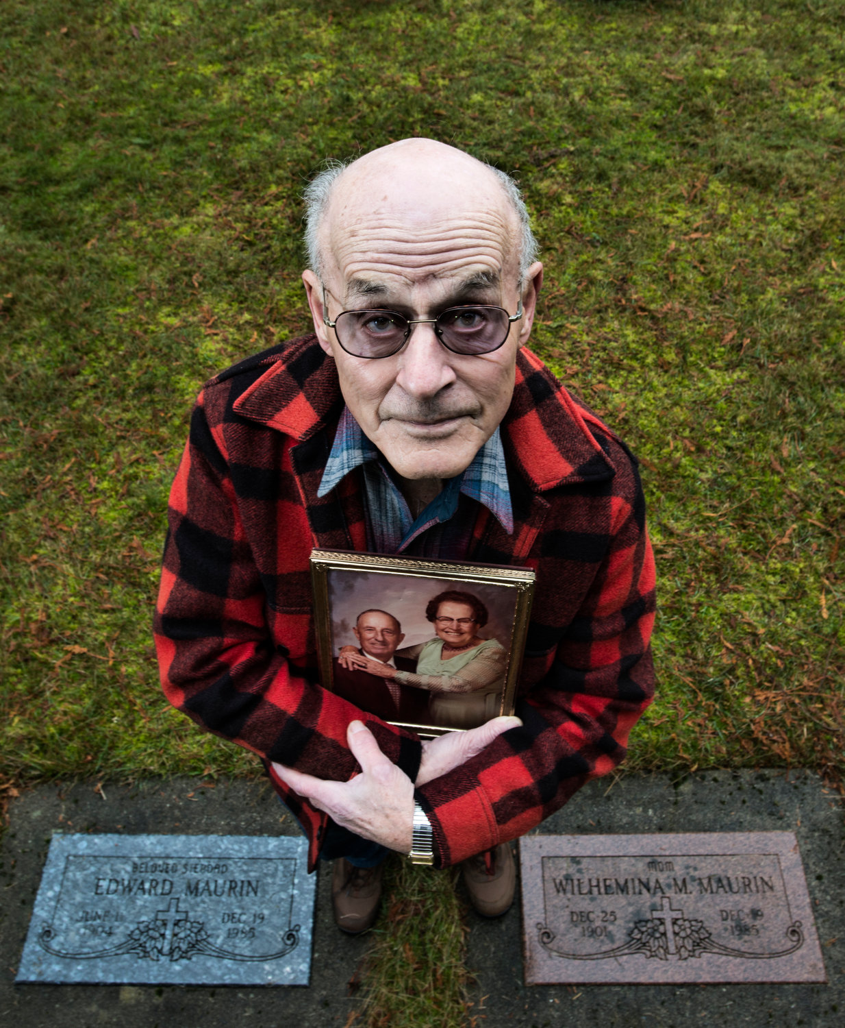 Dennis Hadaller stands next to the graves of his parents, Ed and Minnie Maurin, at the St. Francis Xavier Cemetery in Toledo in this 2013 Chronicle file photo. Hadaller, a former Lewis County commissioner, spent over 25 years searching for an answer to his parents’ deaths.