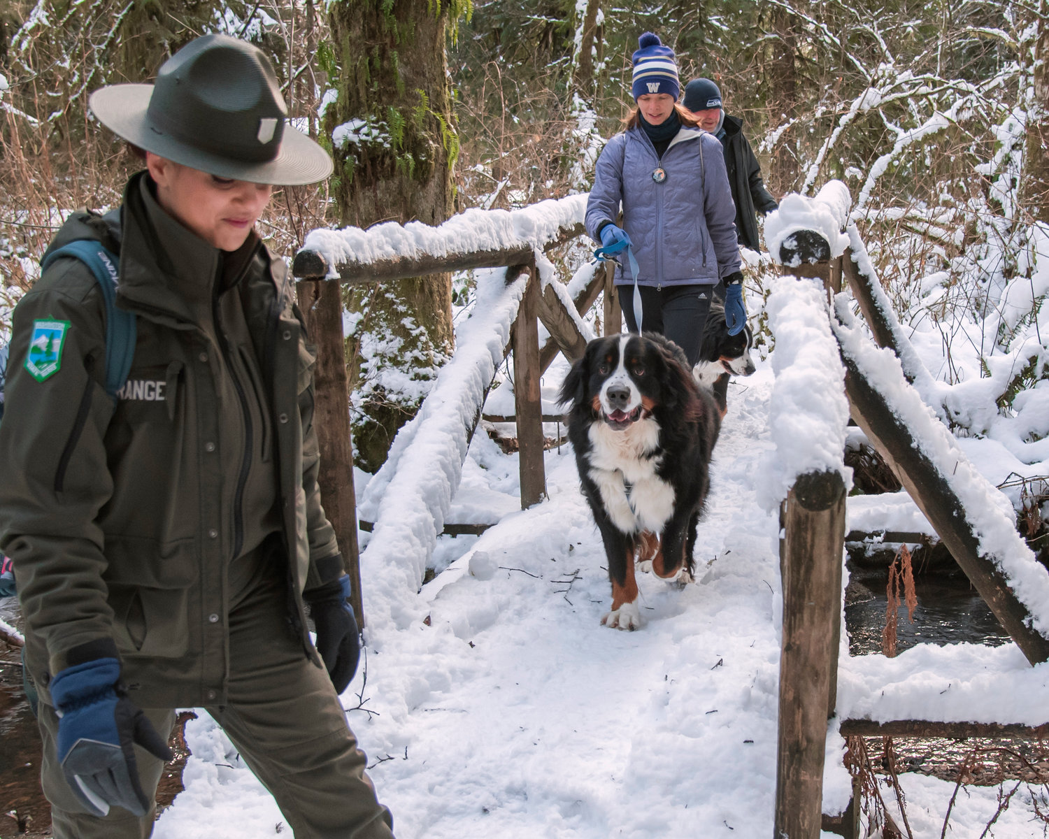 Rangers lead first day hikers and their canine companions along a snowy trail at Lewis and Clark State Park in Toledo on Saturday.