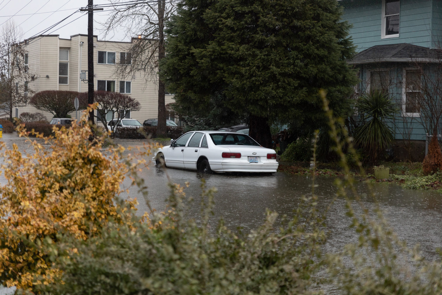 A car is partially submerged under feet of water on North Iron Street at 1 p.m. on Thursday in Centralia.