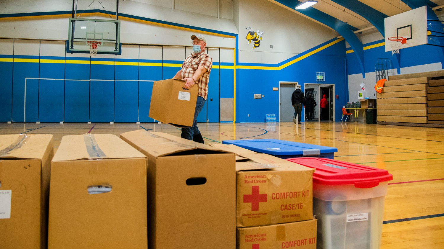 Public Health Director JP Anderson carries American Red Cross supplies into Centralia Middle School Thursday evening.