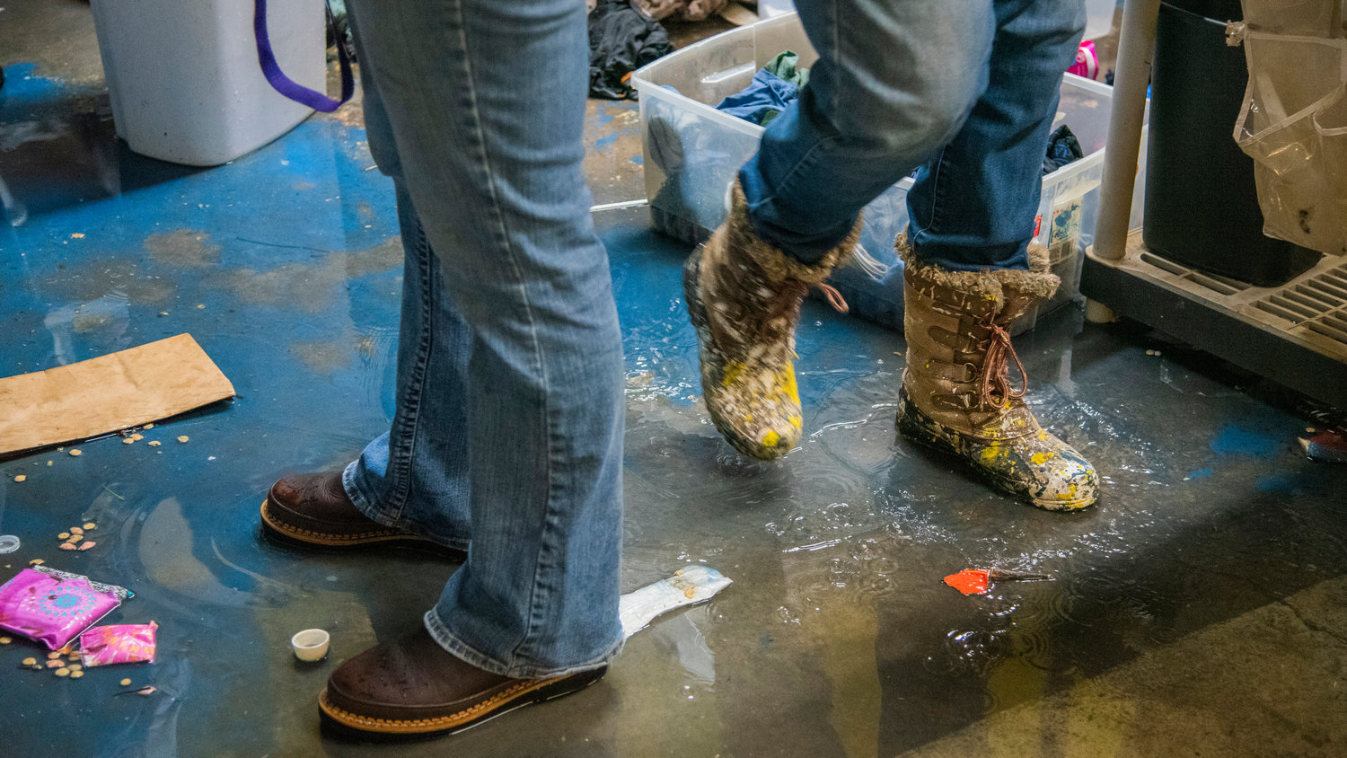 Volunteers walk through water and debris that remains inside Lewis County Gospel Mission in Chehalis after the building experienced flooding.