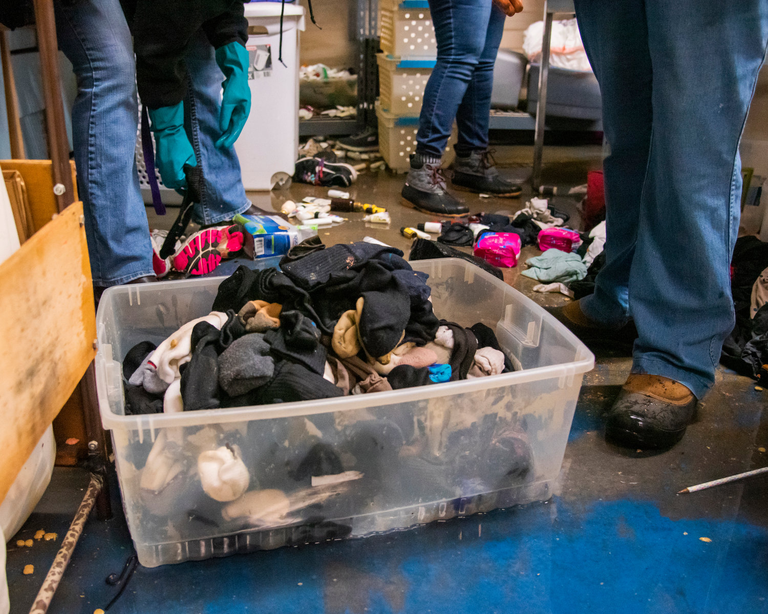 Wet socks are thrown into bins on Monday after shelves toppled into flood water inside Lewis County Gospel Mission.