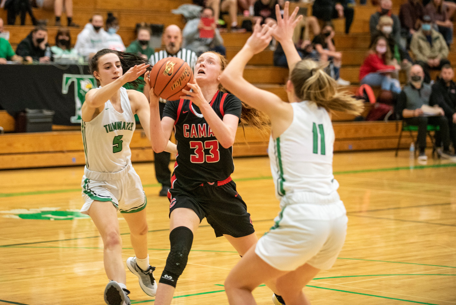 Camas sophomore Addison Harris (33) drives against Tumwater's Natalie Sumrok(5) and Kylie Waltermeyer (11) during a non-league road game on Jan. 10.
